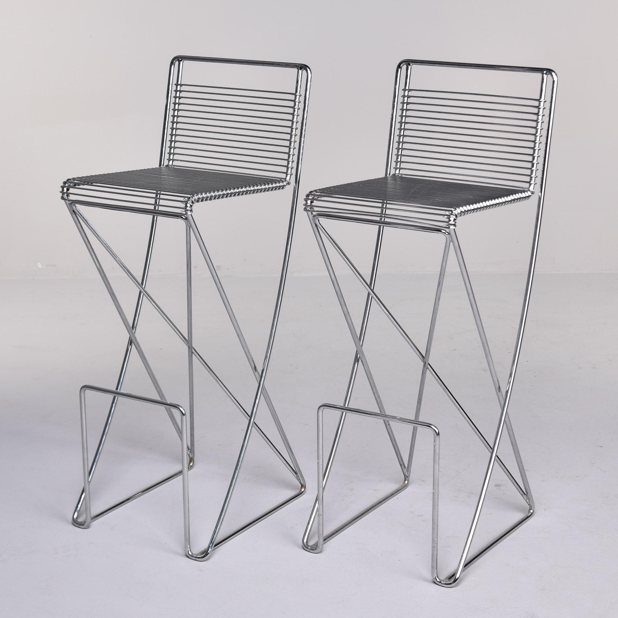 Pair of mid century industrial style chromium-plated metal bar stools by Till Behrens for the Schulbach company’s series Kreuzschwinger. These circa 1980s cantilever bar stools are very comfortable and sturdy with footrests and bar-height seats.