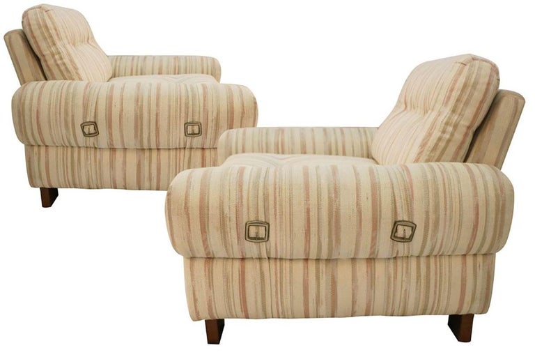 A pair of exceptional Mid-Century Modern low upholstered and padded club armchairs in the style of Tobia Scarpa. Featuring subtly striped button-tufted upholstery with two bucked straps on rounded arms, three buttons on loose back and seat cushions