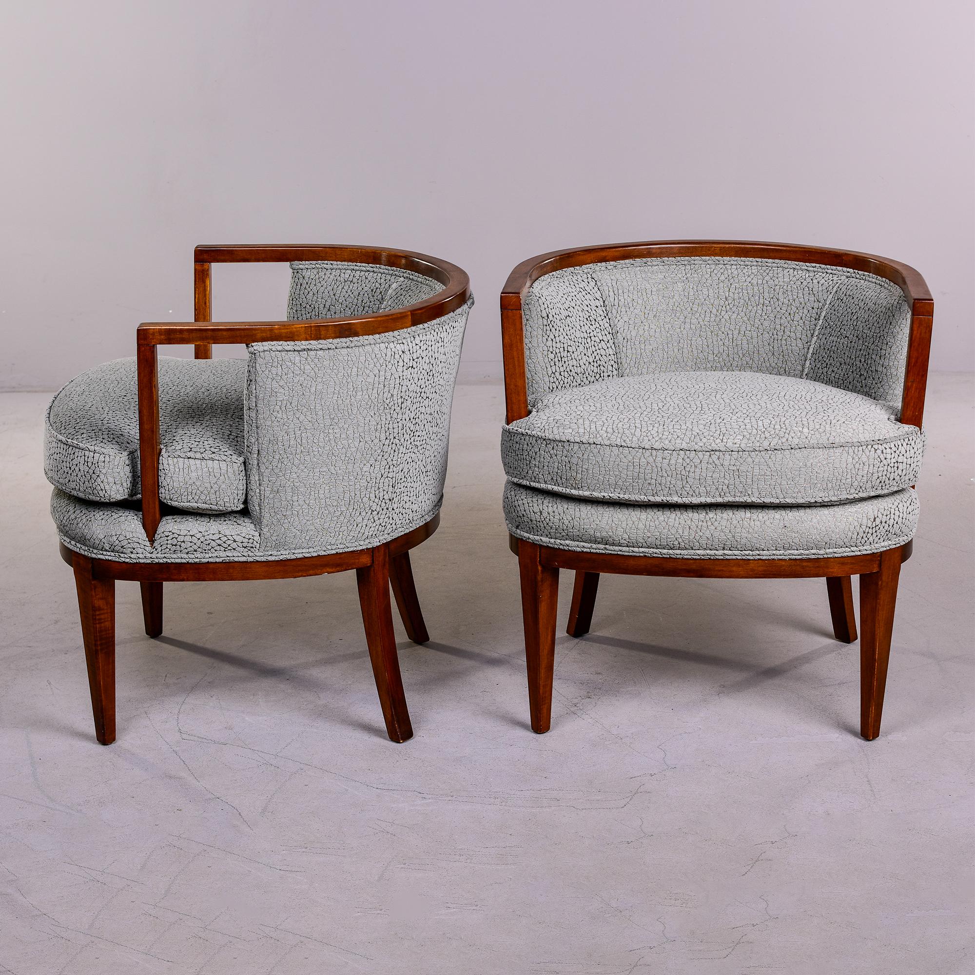 Found in the US, this pair of circa 1960 club or tub chairs have sleek walnut frames with open arm details, and rounded, tub/barrell-form low backrests, tapered legs. Chairs have been reupholstered in a Pindler chenille that is a grayish-sage green