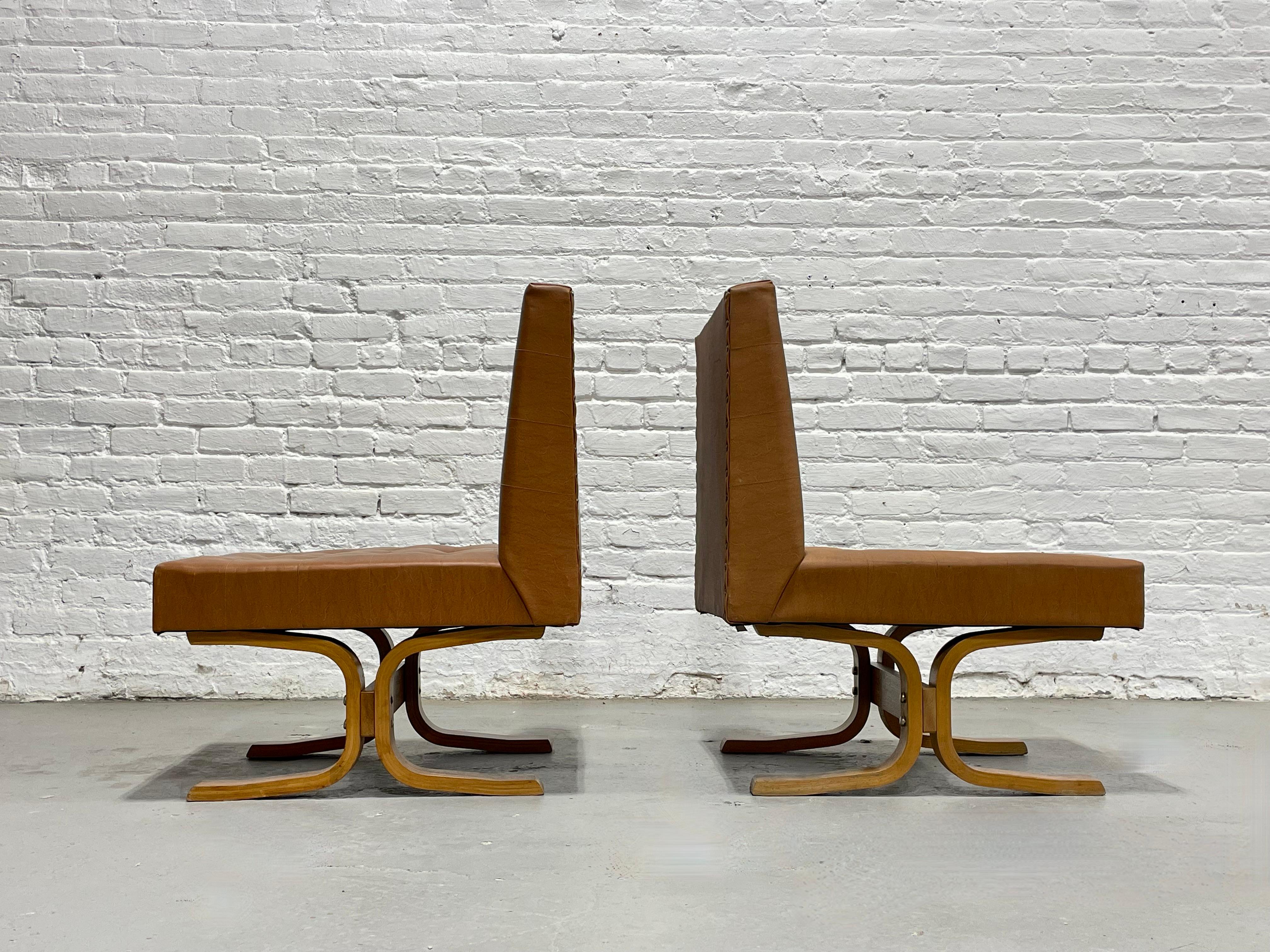 Tufted pair of low slung Mid Century Modern lounge chairs by Ludvik Volak for Drevopodnik Holesov, made in Czechoslovakia, c. 1960’s.  The chairs feature sculptural bentwood bases and original caramel-toned vinyl upholstery. Designed with clean