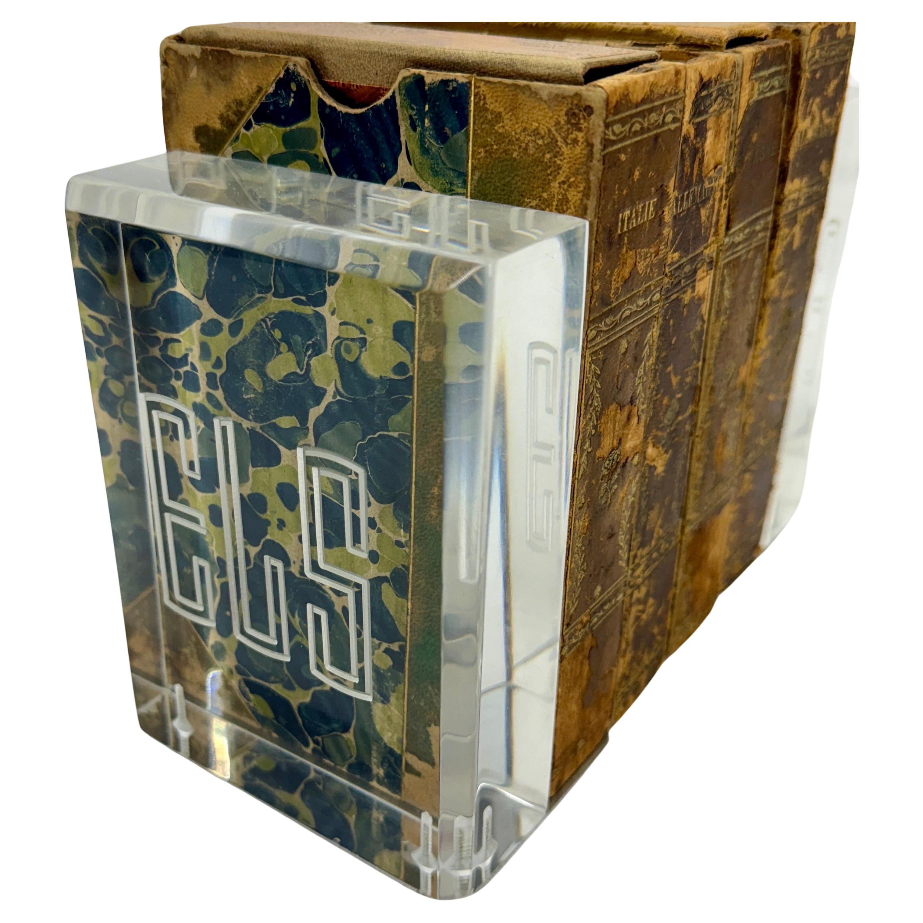 Coppia di reggilibri in lucite alti e pesanti con monogramma, con bellissimi bordi smussati e basi in alluminio. Questi fermalibri quasi brillano quando la luce li colpisce. Lucida e sostanziosa, questa coppia è un'ottima aggiunta a qualsiasi