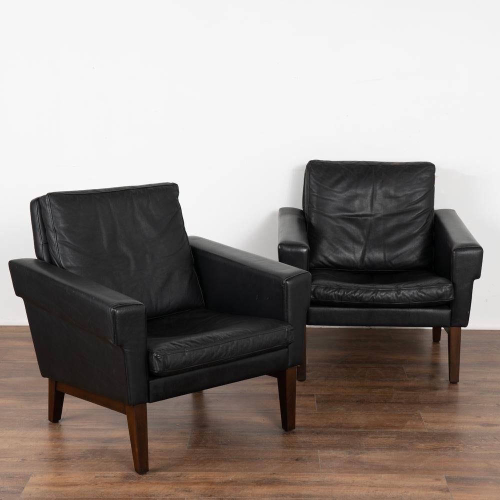 Pair, mid-century modern black leather arm chairs.
Clean modern design with squared arms, these chairs sit comfortably on hard wood feet.
Sold in vintage used condition. Leather shows typical signs of wear including scuffs, scratches, minor