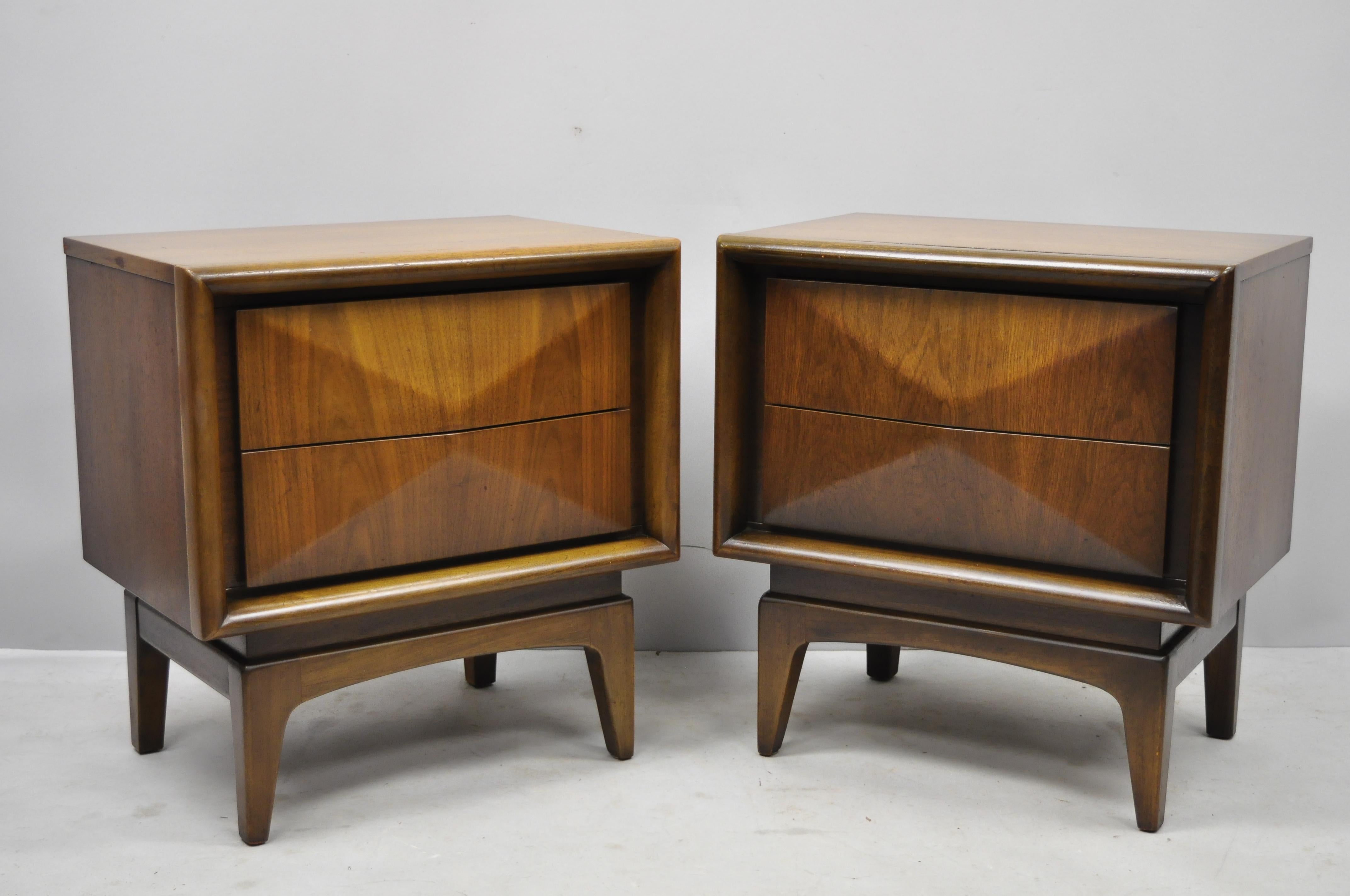 Pair of Mid-Century Modern diamond front walnut nightstands bedside tables by United. Items feature wood construction, beautiful wood grain, 2 dovetailed drawers, tapered legs, great style and form, circa 1960. Measurements: 25