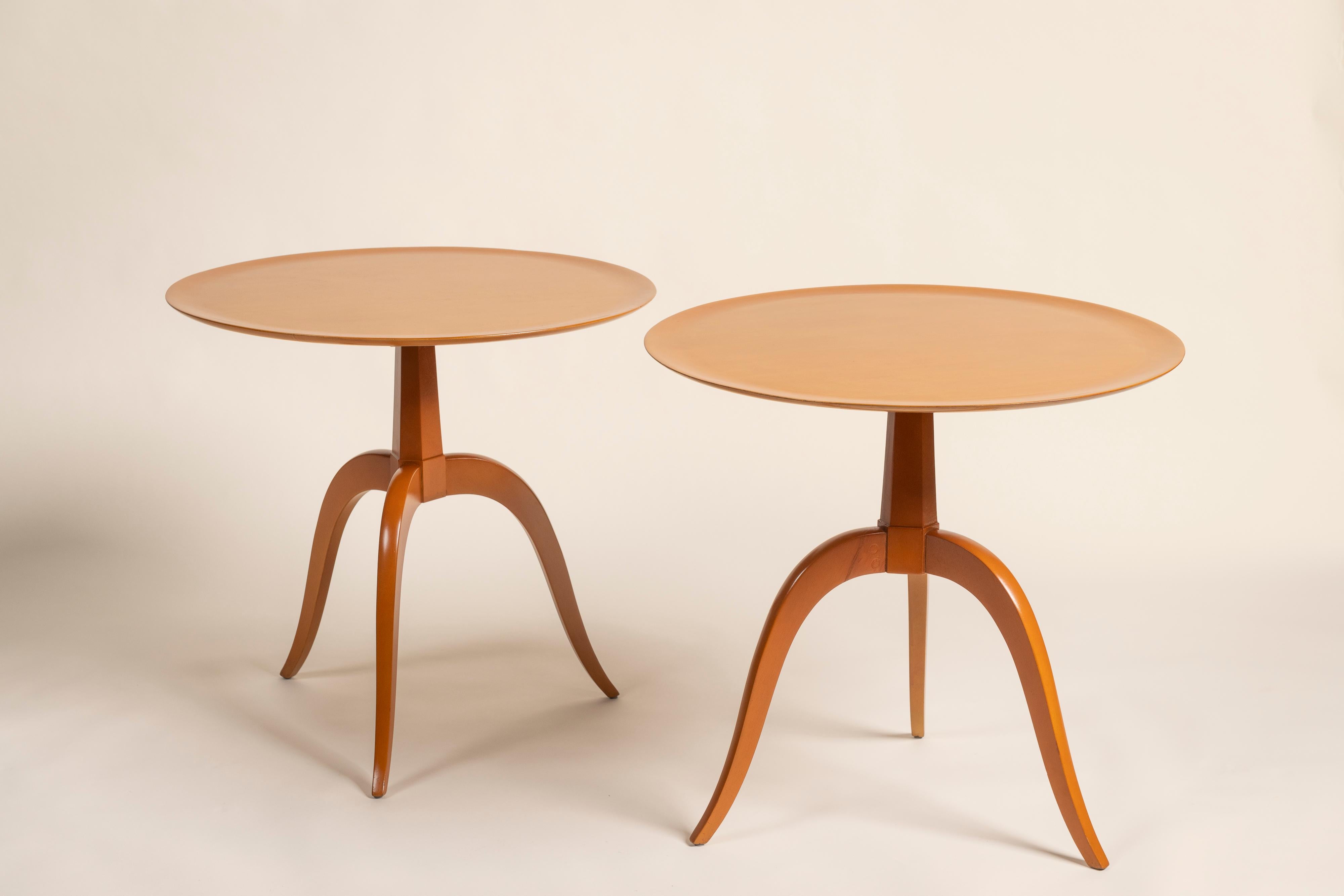 An exceptional pair of Edward Wormley for Dunbar side tables, featuring round dish tops gracefully supported by three sleek saber legs. The design offers a refined, modern silhouette with a slim profile, perfect for versatile placement. Crafted from