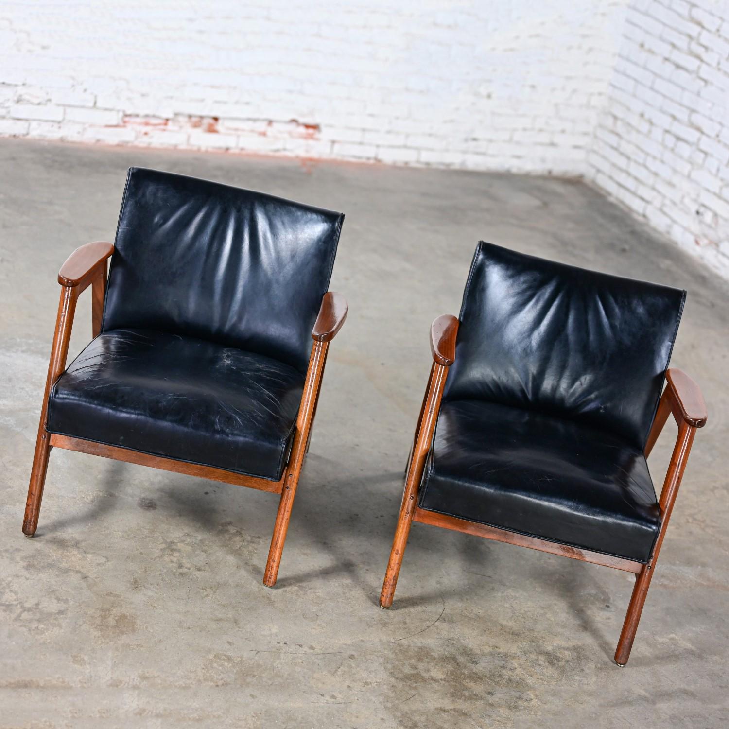 Marvelous vintage Mid-Century Modern pair of Gunlocke armchairs comprised of walnut frames, black leather fabric seats & backs, & steel nail head trim detail. Beautiful condition, keeping in mind that this is vintage and not new so will have signs