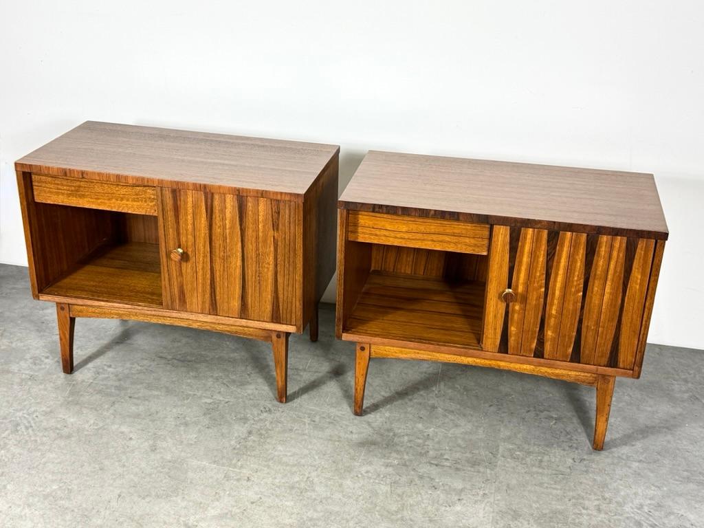 A pair of night stand or end tables by Lane Furniture circa 1960s
From a more rare line in rosewood and satinwood with inlaid bow tie detailing

Sliding door for interior storage and a single drawer which can be used on either side.  Finished with