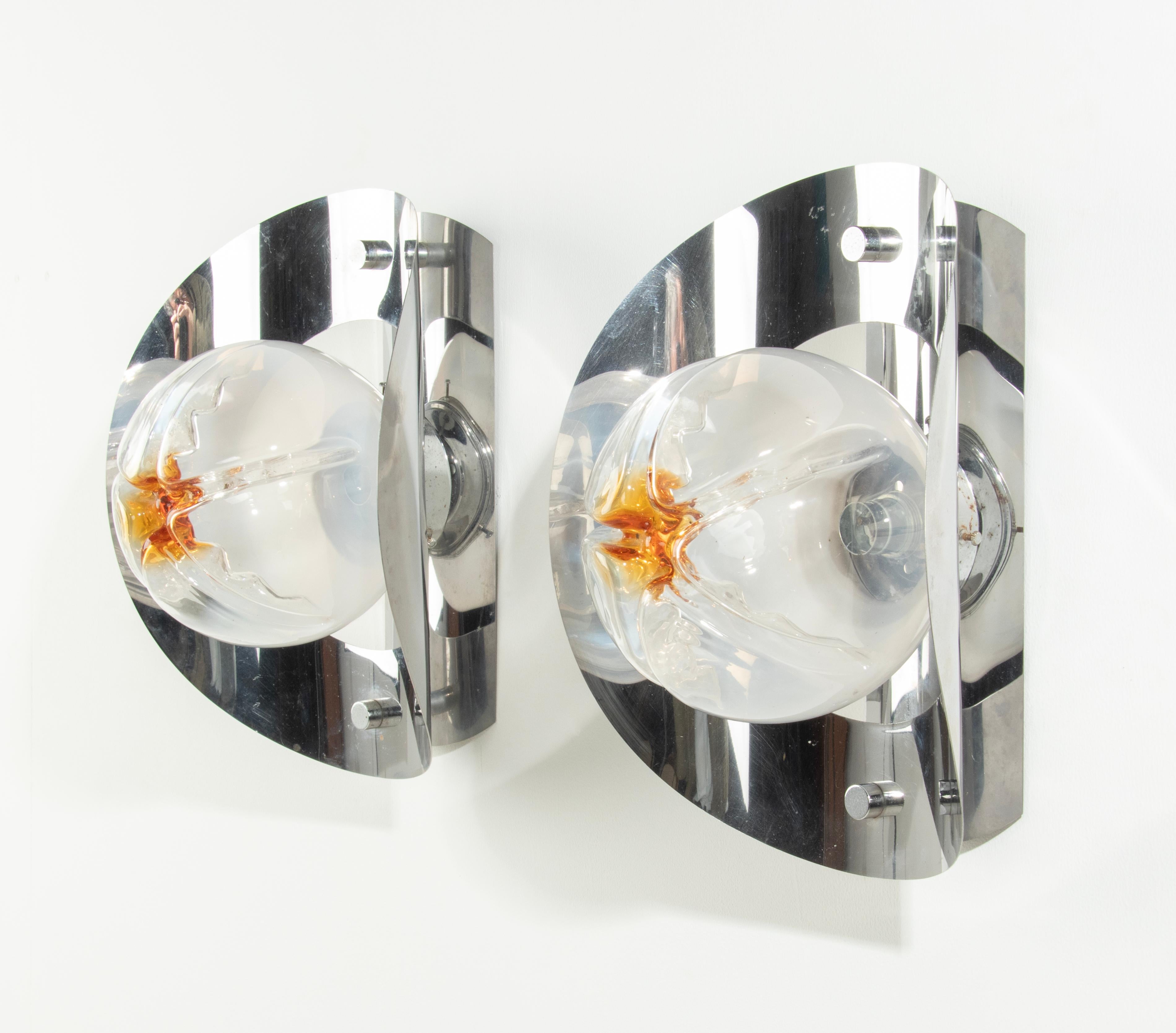 A pair of Italian Mazzega wall sconces/lights. Made of chrome plated metal, with Murano Glass globe glass shades. Bayonet lamp socket. Suitable for 220-240 Volt. The lights are in working order. The chrome plating is in good vintage