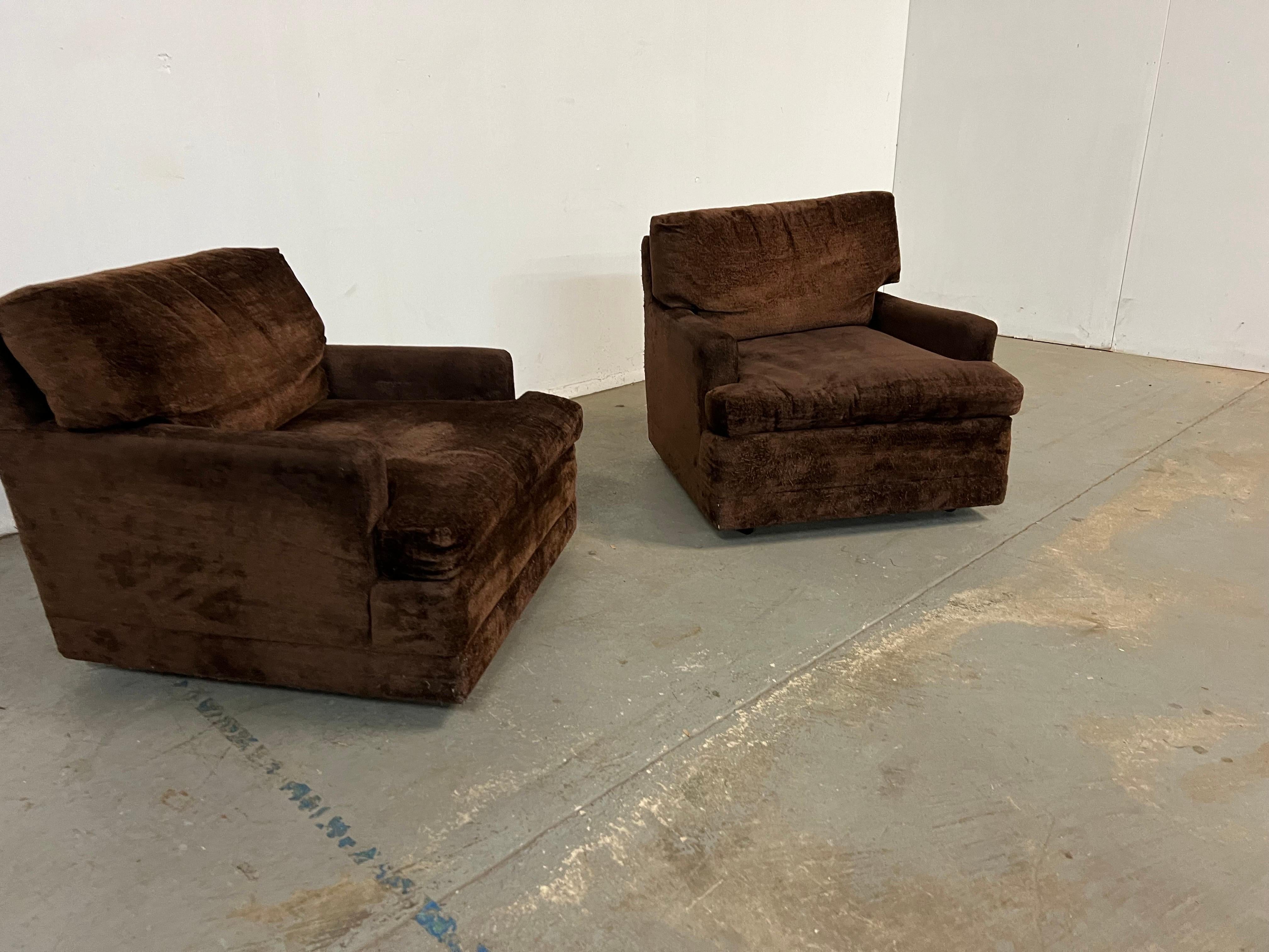Offered is a pair of vintage Mid-Century Modern style lounge/club chairs on rollers. The Cube design is in line with the era -true Lounge Pit Chairs-Deep and Low. The chairs are quite confortable. Perfect for any space or design project, make them