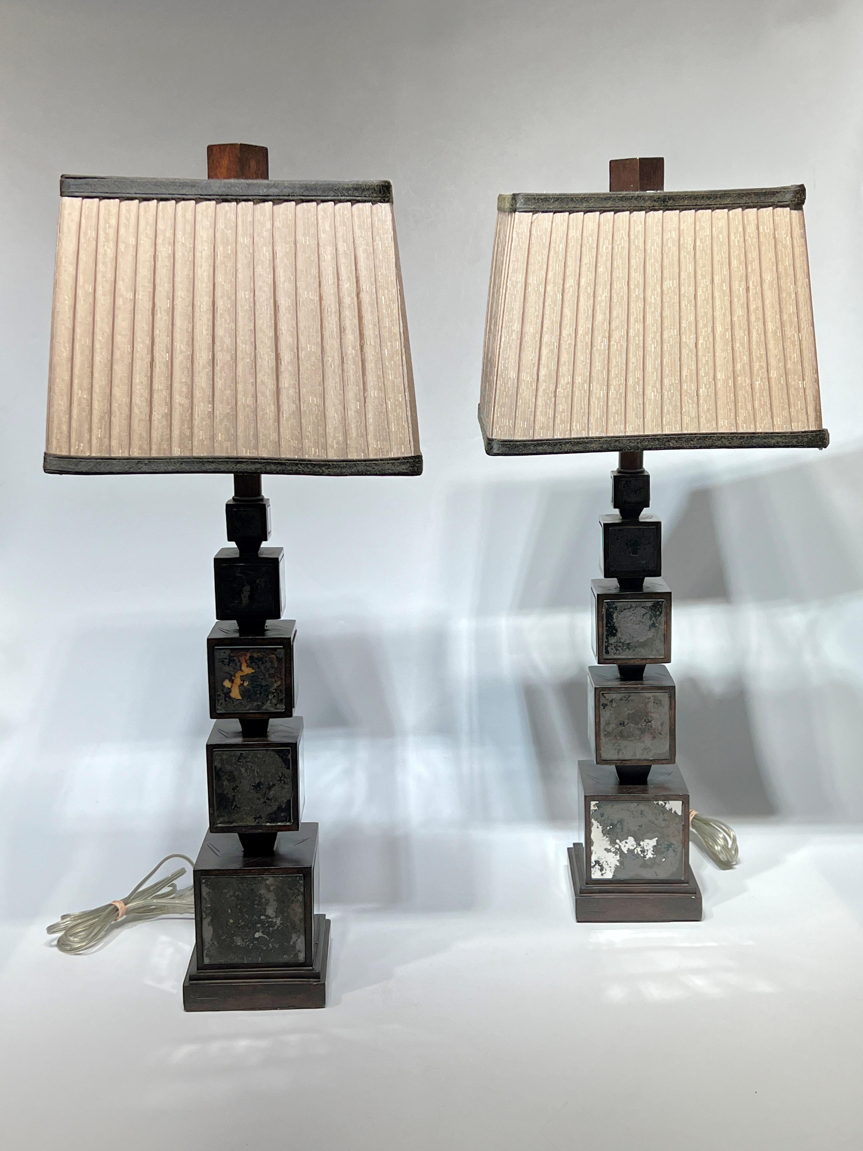 Paire de lampes de table modernes du milieu du siècle, fabriquées à partir de blocs de bois avec une finition teintée brun foncé, insérés dans des panneaux de verre miroité, et de nouveaux abat-jours en tissu de forme rectangulaire mesurant 12 par