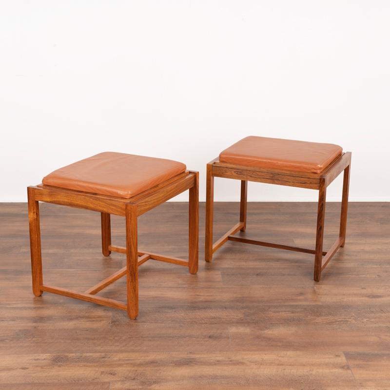 This unique pair of Mid-Century Modern stools were built by a Danish furniture manufacturer. Unique to these stools is that the seat which is upholstered in brown leather is reversable, turning the stool into an attractive small side table with