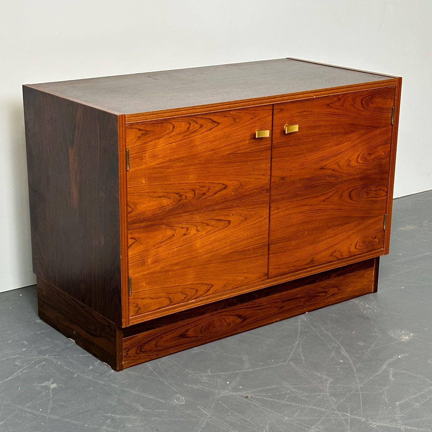 Pair of American Mid-Century Modern Rosewood Nightstands / Cabinets or Chests, Brass Pulls
 
 
A fine pair of cabinets or bedside stands crafted in rosewood.  Each case has double doors with brass pulls and a single shelf interior.  The slight lift