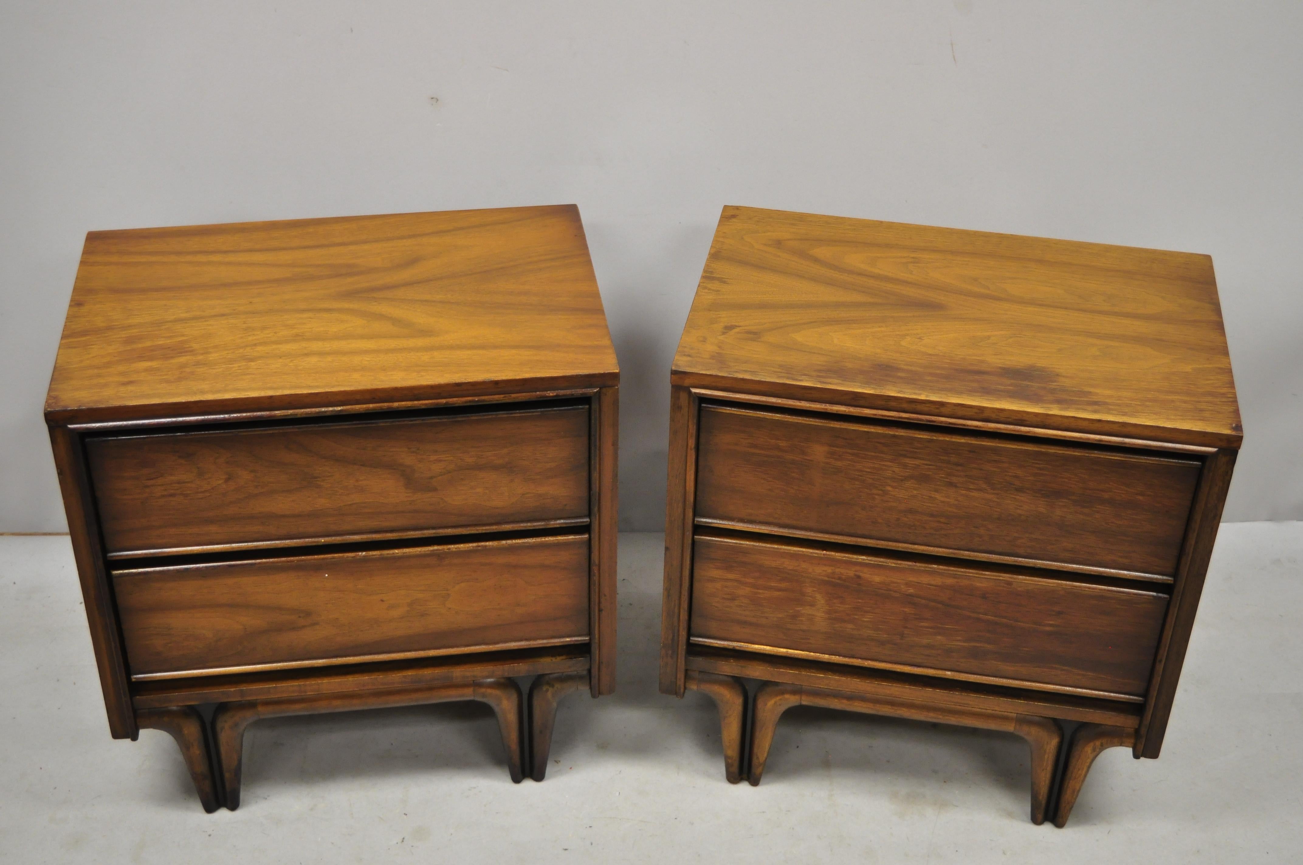 Pair of Mid-Century Modern sculpted walnut V-leg nightstands bedside tables. Item features sculpted and tapered 