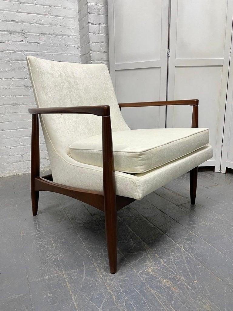 Pair of Mid-Century Modern sculptural lounge chairs style of IB Kofod-Larsen. Has a walnut sculptural frame and newly upholstered in cream fabric.