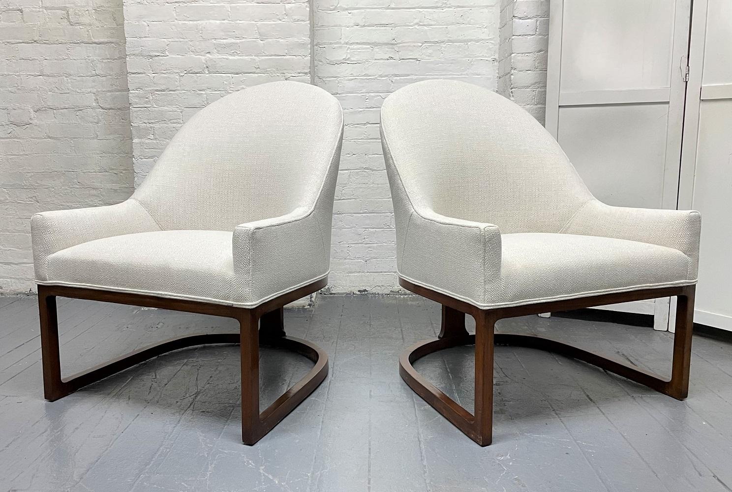 Pair of Mid-Century Modern upholstered side chairs. The chairs have sculptural walnut frames. Also have tufted loose cushions. Chairs are newly upholstered. In the style of Harvey Probber.