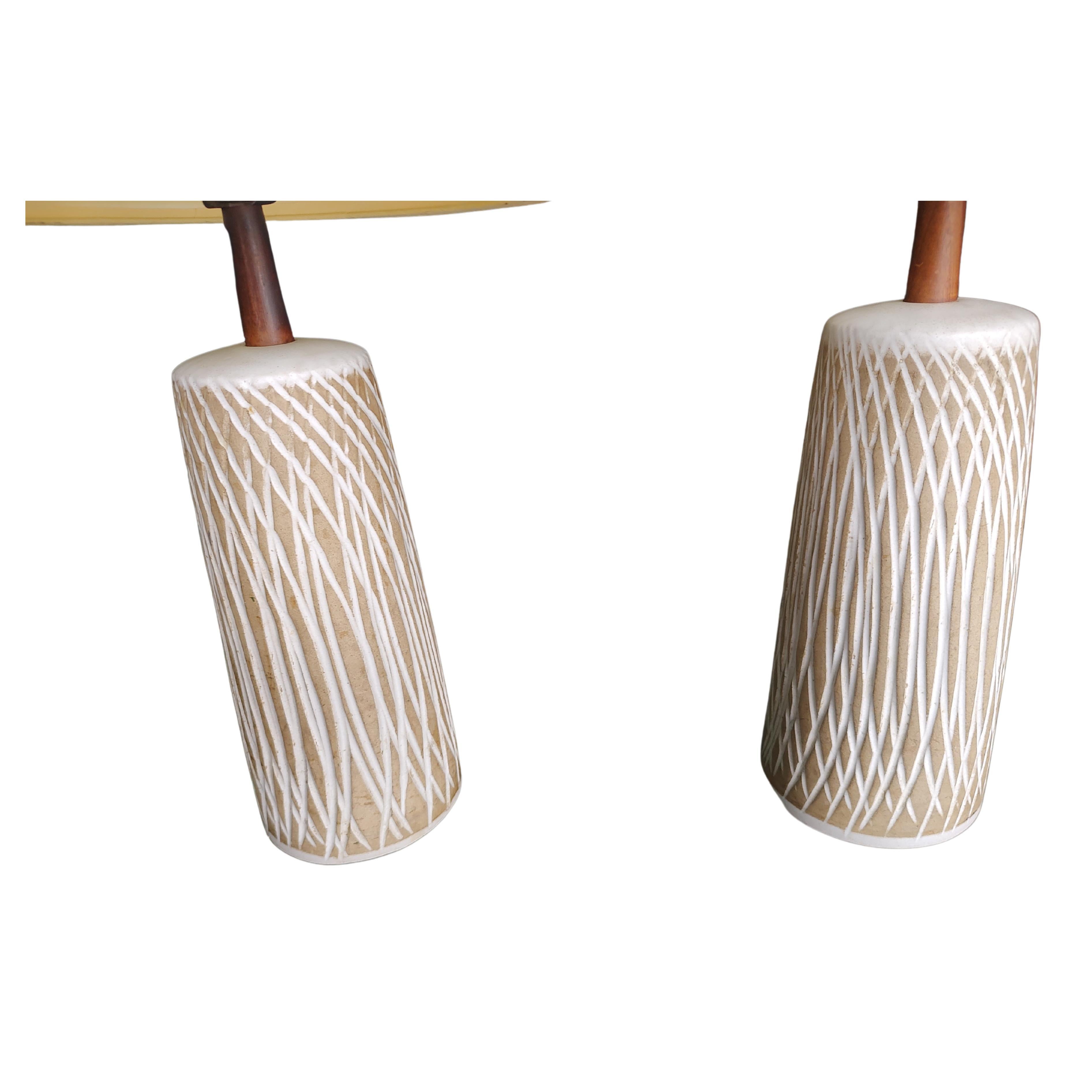 Fabuloso par de lámparas de cerámica lanzadas y grabadas a mano por Gordon & Jane Martz, perfectas para el dormitorio. En excelente estado vintage con desgaste mínimo, los tonos tienen decoloración, amarilleamiento leve. Vástagos y remates de nogal.
