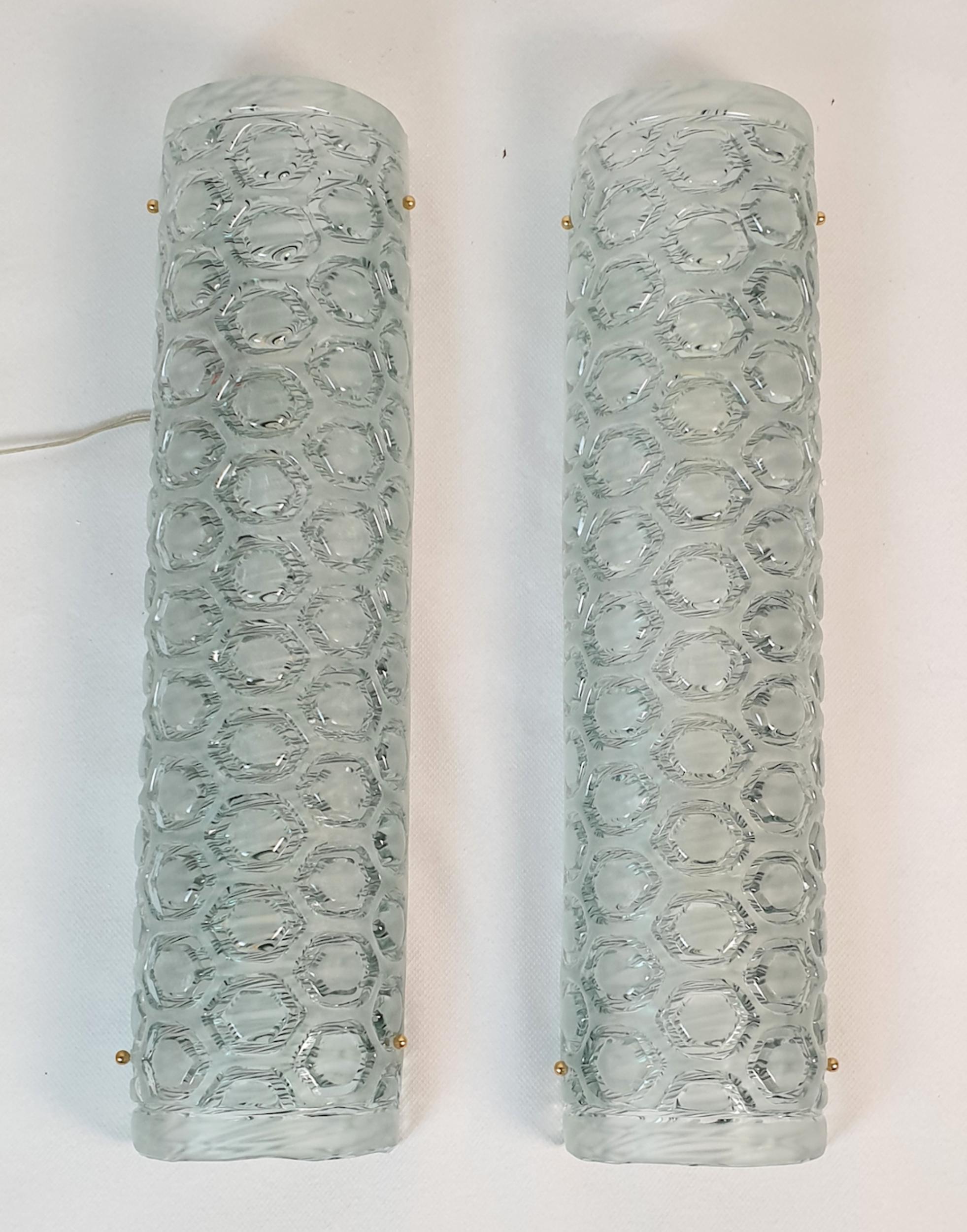 Pair of tall Mid Century Modern Murano glass wall sconces, attributed to Mazzega, Italy 1980s.
The vintage sconces are made of a light green frosted Murano glass.
There is a nice medallion pattern showing the thickness of the glass, which is frosted