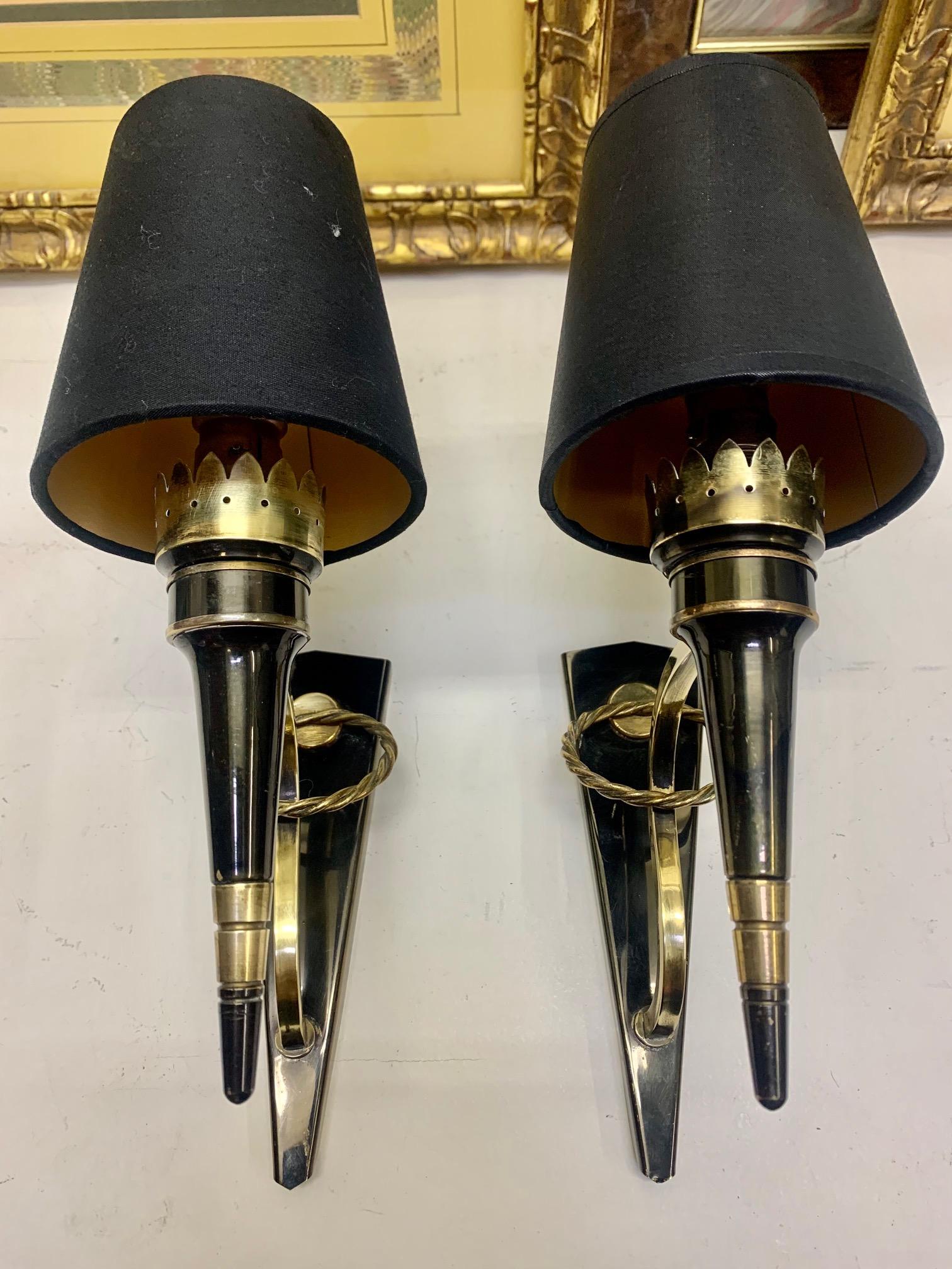 French mid-century pair of wall sconces by Arlus, Brass and netal laquered, with decoration of a brass circle, the lampshades are black with the interior in gold. They are in very good condition and ready for operation in the USA.