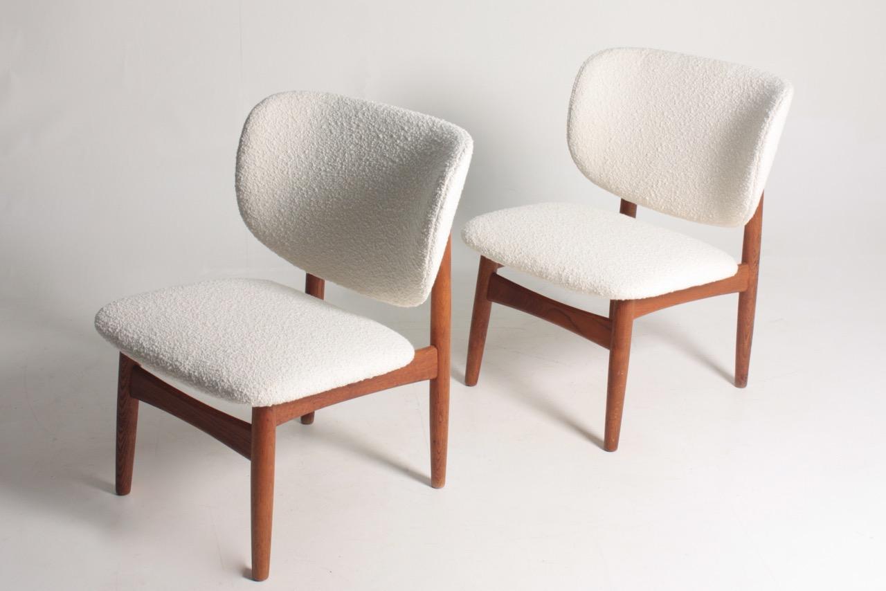 Pair of lounge chairs in solid oak, upholstered in bouclé. Designed by Kurt Østervig, made by KP Møbler in the 1960s. Great condition.