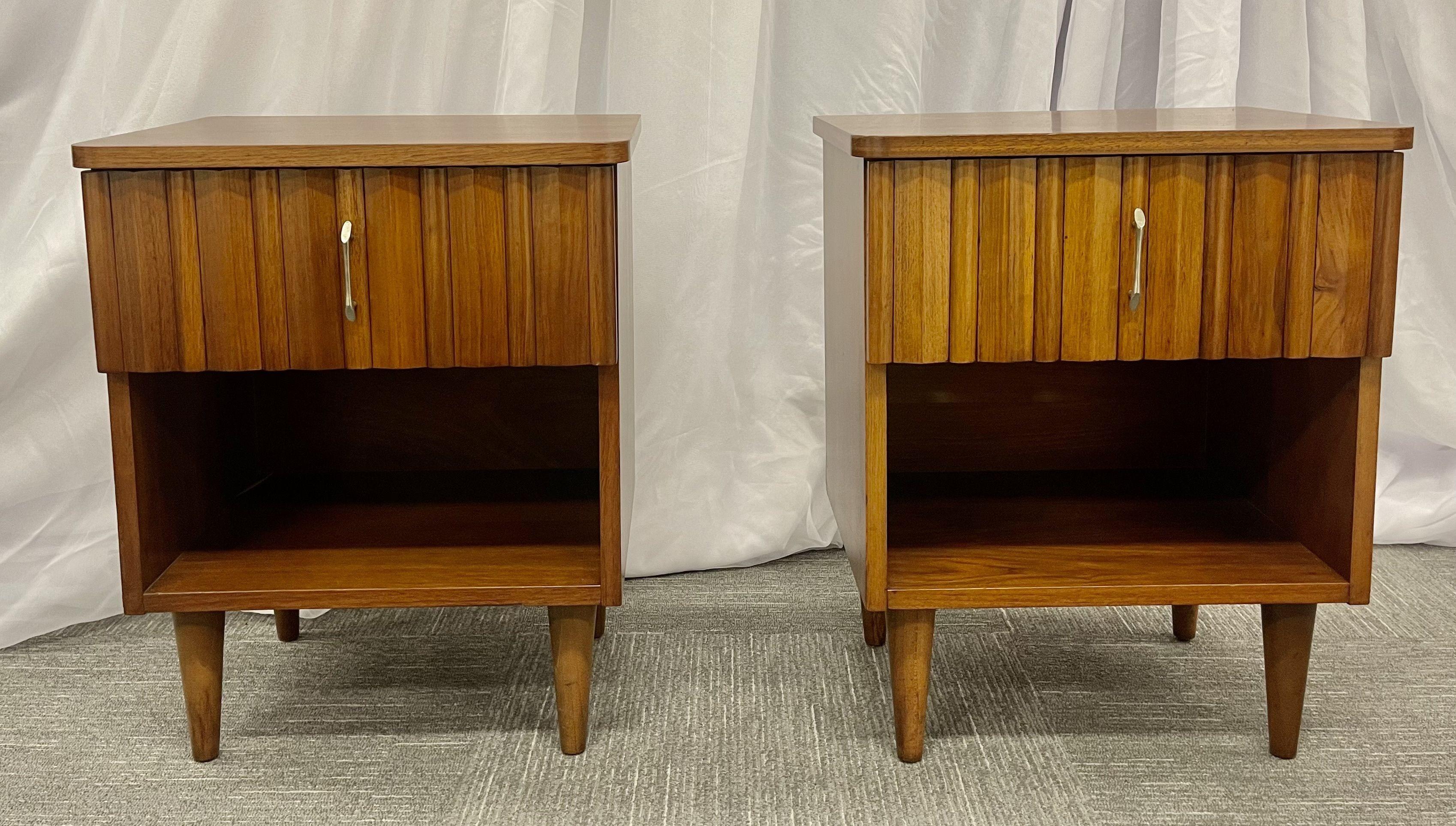 Pair mid-century open nightstands, side/end tables.

Pair of newly refinished mid-century modern nightstands each having a single drawer above an open storage compartment. Standing on four straight legs. American studio made, comprised of solid