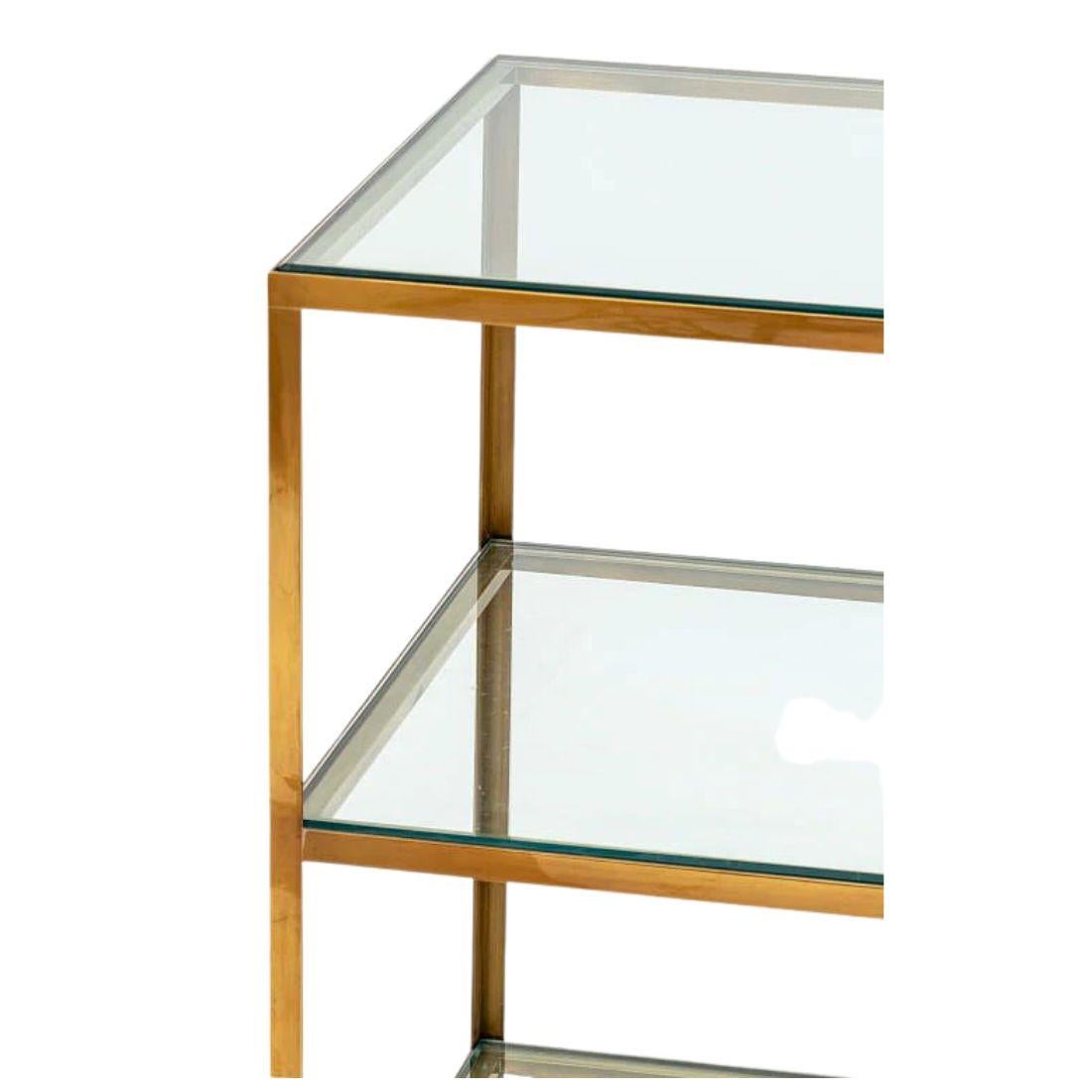 Sophisticated and versatile, this pair of three-tier side tables showcases a refined contemporary take on Mid-Century Modern design. Each table features a clean, geometric brass frame crafted in the form of an open étagère, offering a light, airy