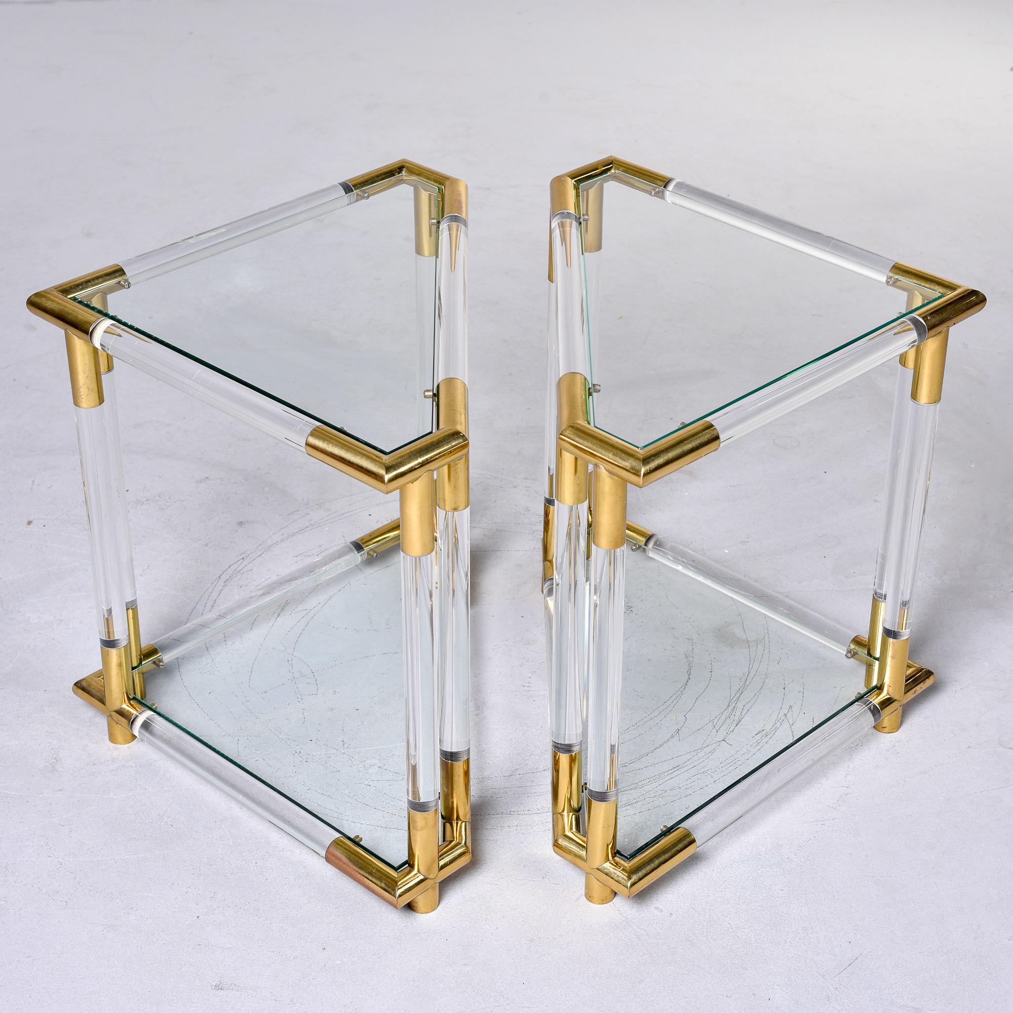 Found in Italy, this pair of circa 1970’s triangular side tables feature lucite and brass frames with glass tops and lower shelves. Very good vintage condition with minor scattered surface wear to frames and glass. Unknown maker. Sold and priced as