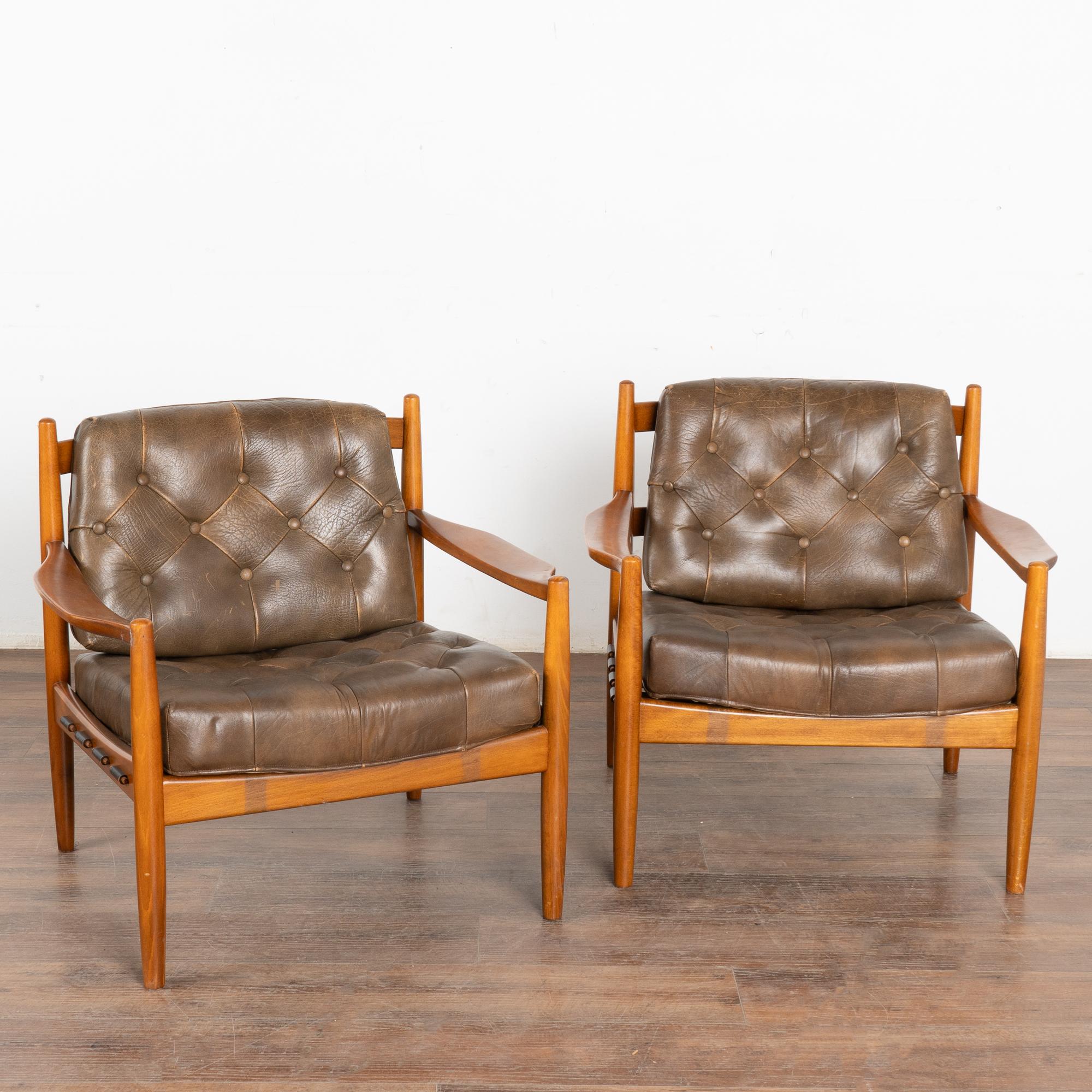 Pair, mid-century modern brown leather arm chairs with tufted back and seat.
Clean modern design with hardwood frame, these chairs sit low and comfortable.
Sold in solid, vintage used condition. Frame and leather shows typical signs of wear