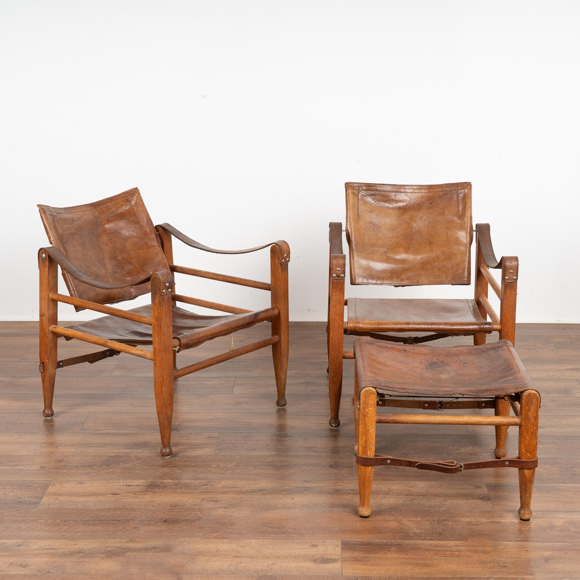 Pair of Mid Century modern brown leather safari chairs and ottoman from Denmark.
Leather seat, swing back and arm rests all set on hard wood frame.
Sold in vintage used condition, leather shows typical age-related wear with stains,crackling, wear