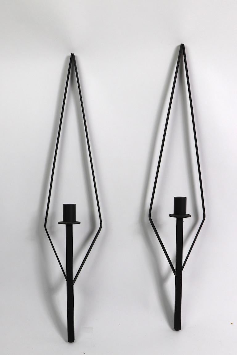 Elegant elongated diamond shaped backs support a single arm candle sconce. Wrought iron construction, clean, original condition. Matched pair selling together, design in the manner of Paul McCobb.