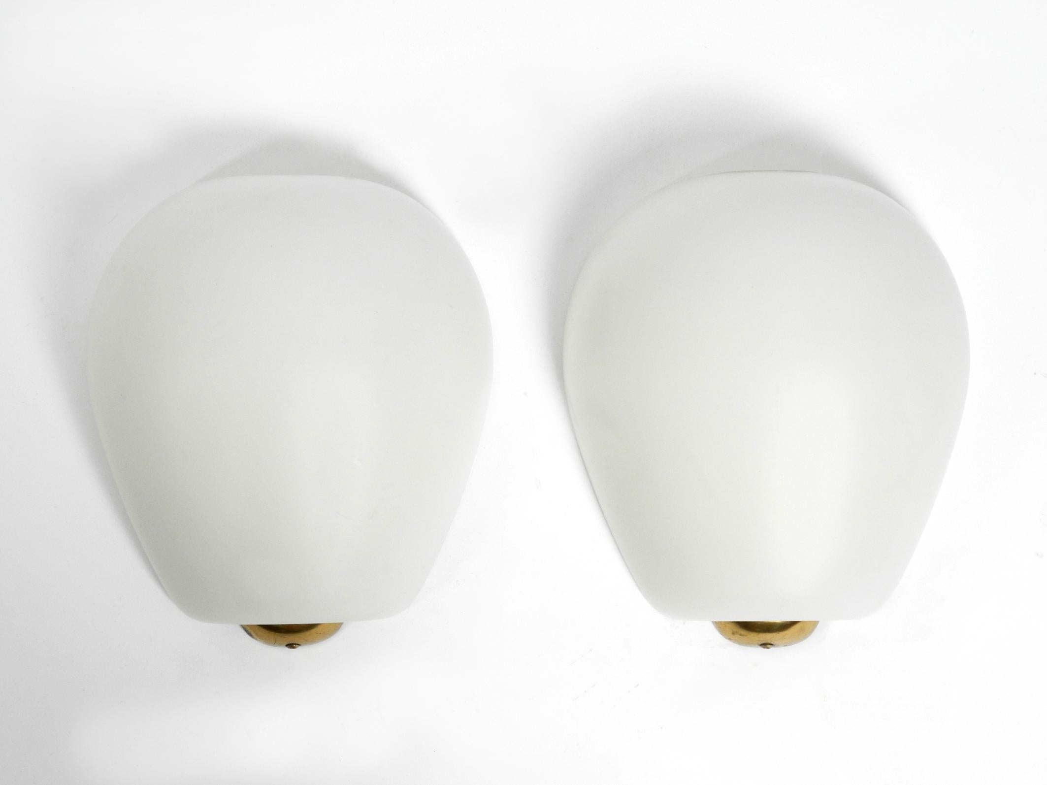 Pair of elegant very rare large Mid-Century Modern glass 'shell' wall lights by Wilhelm Wagenfeld. Manufactured by Peill & Putzler in the 1950s. Very rare in this large version.
Glass shade is made of a special flashed glass in matt white with