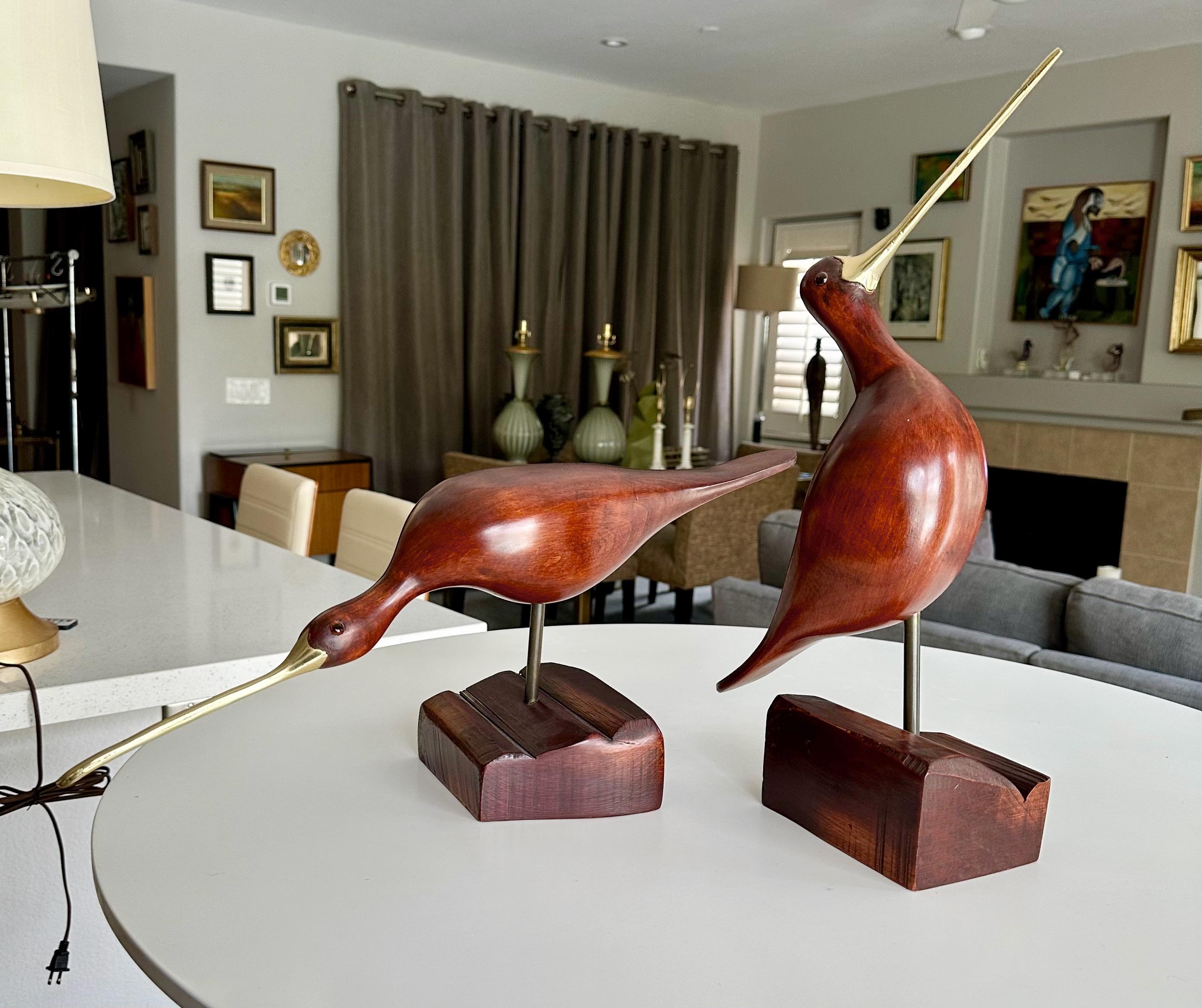 Paire de sculptures d'oiseaux bécasseaux vintage sculptées à la main avec des becs allongés en laiton et des yeux en verre, chacune montée sur des bases stylisées en bois sculpté. 
Chaque mesure :
9