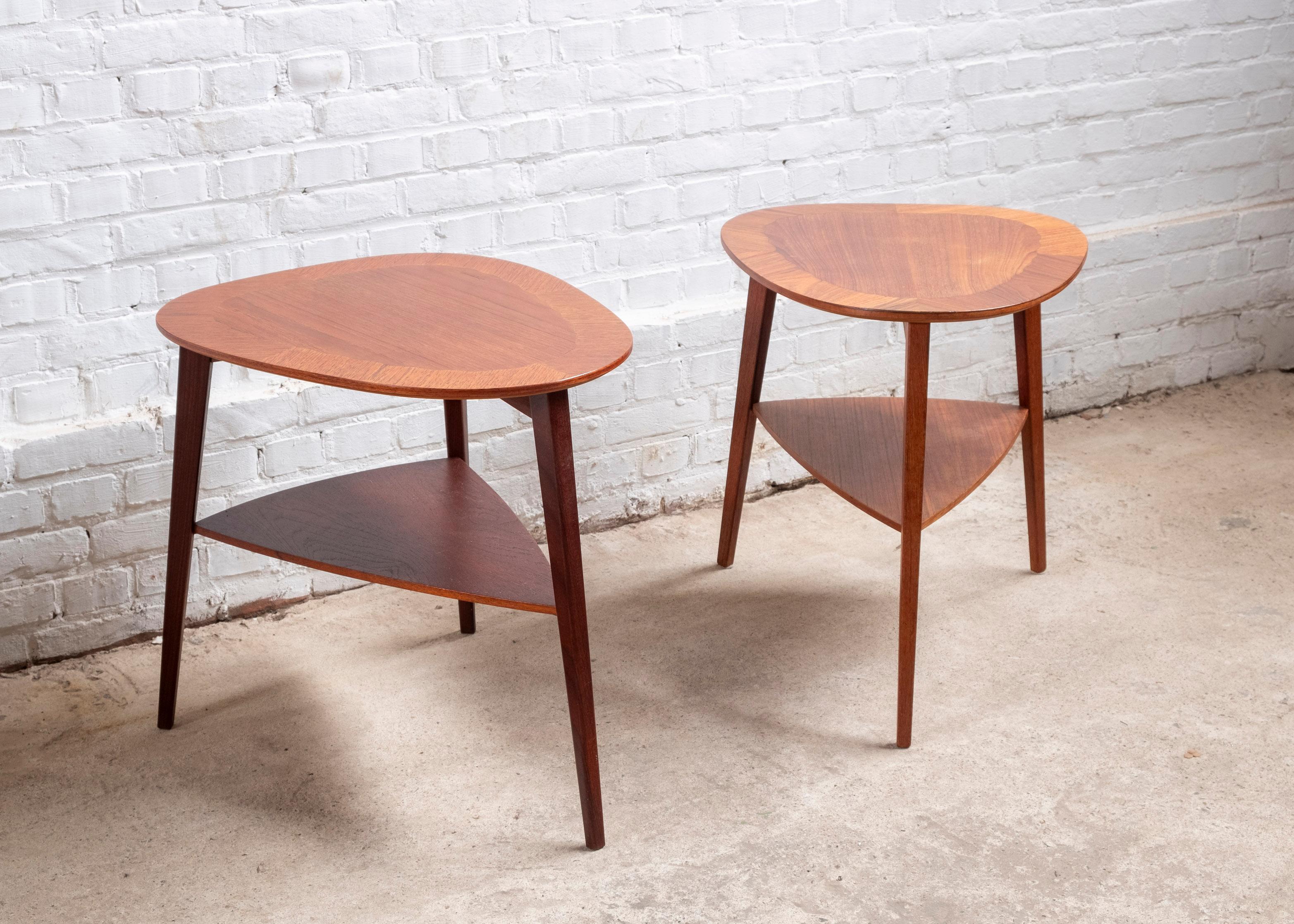 A pair of Danish modern teak end tables by Holger Georg Jensen for Kubus in Denmark. Produced in the 1960s
The table is beautifully crafted, the top shows quartered border of contrasting grained teak marquetry, with secondary suspended shelf on