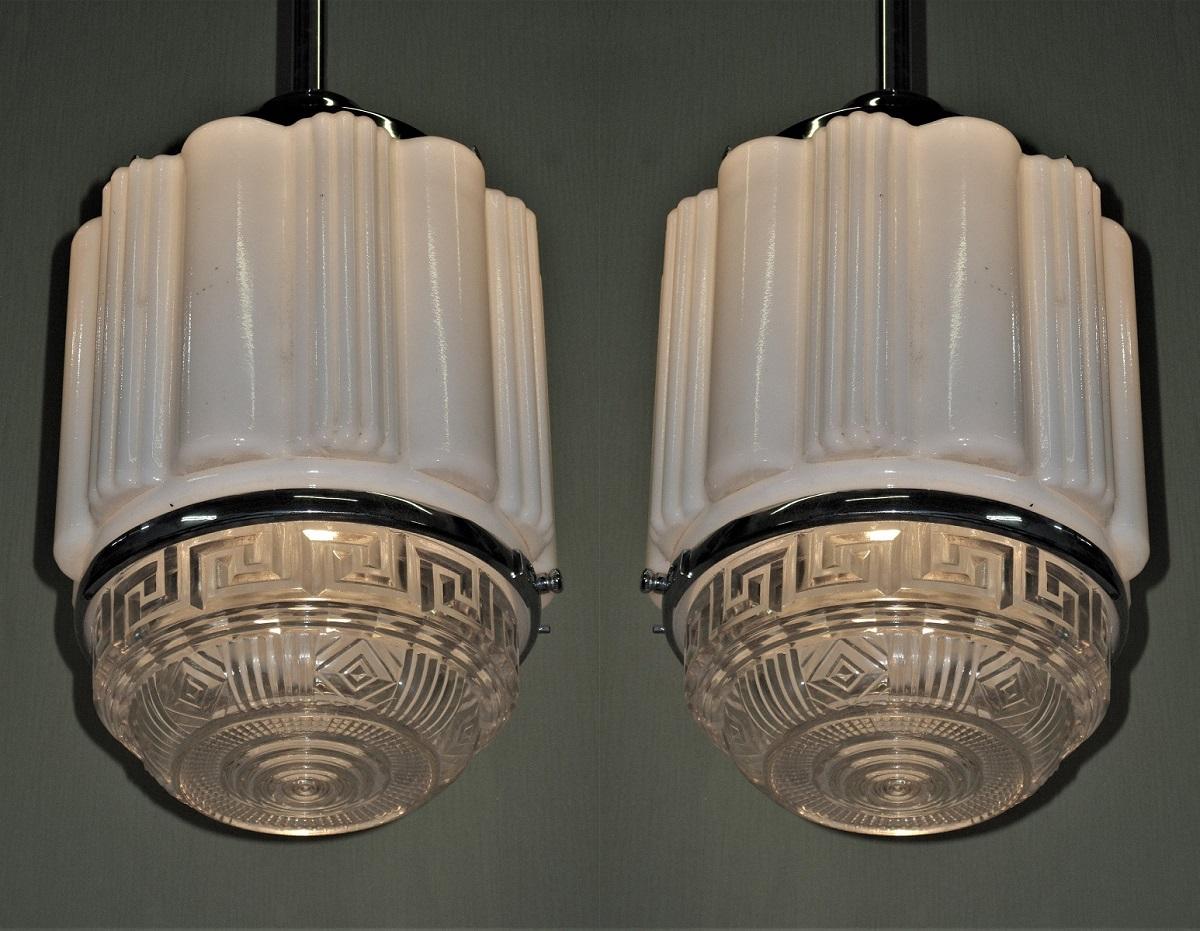 Priced for the pair.
Department or drug store fixtures from the 1920s shown on a new nickel fitter. Pleated and ribbed milk glass upper section with a nicely patterned crystal glass bottom with Greek key and deco design.
Globe is 9 inches