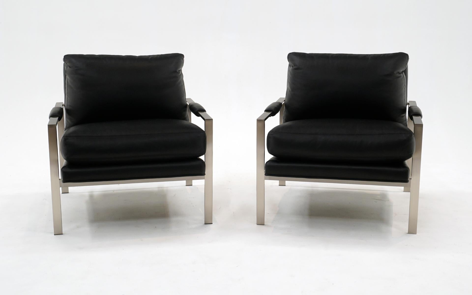 Black leather and brushed steel lounge chairs with arms designed by Milo Baughman and made by Thayer Coggin. These are newer production and appear to have had very little use. No tears, scuffs, holes or repairs to the leather. Possibly some light