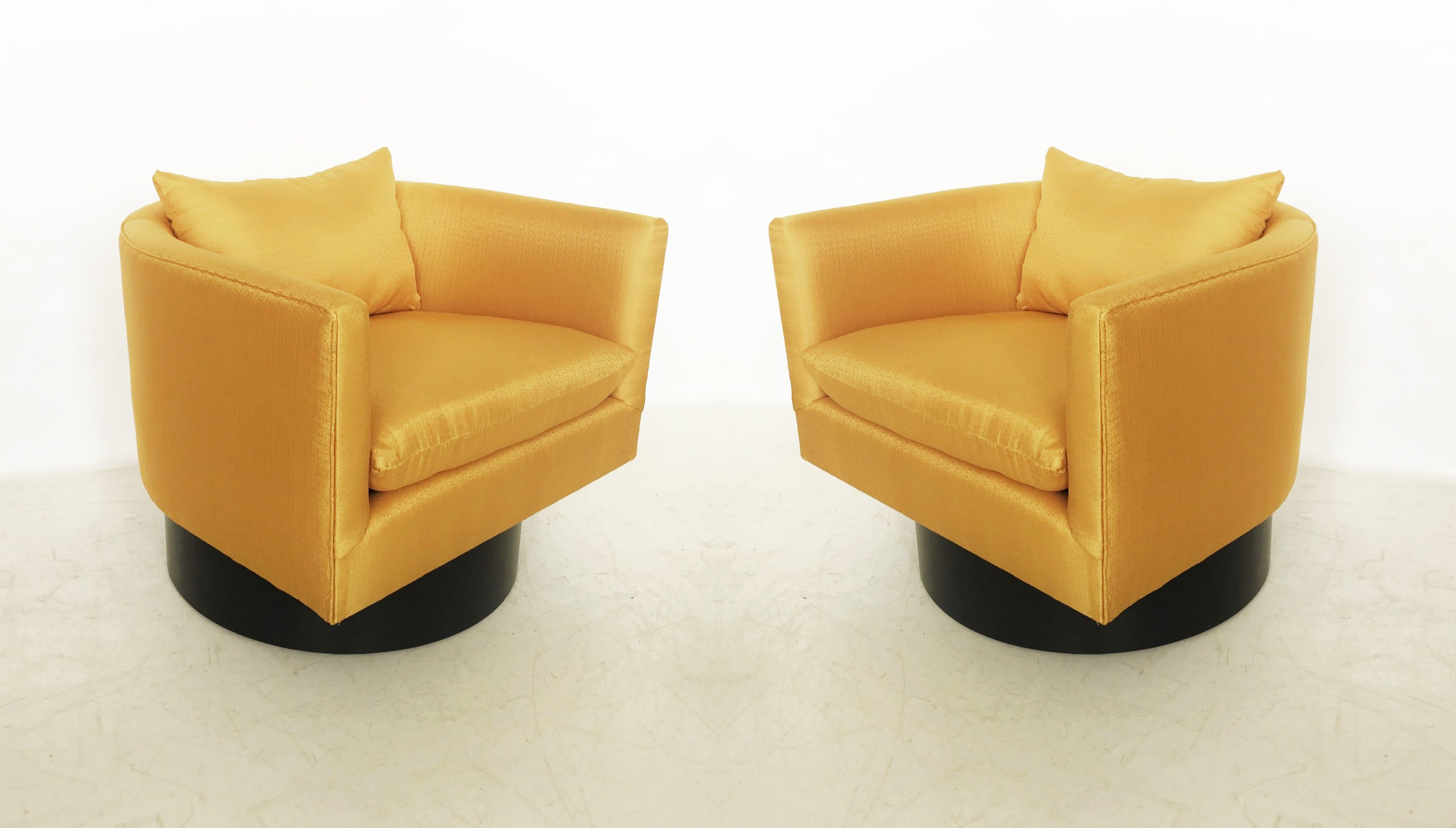 Pair of unusual swivel chairs on high ebonized bases designed by Milo Baughman for Thayer Coggin. Restored and newly upholstered in yellow gold fabric.
