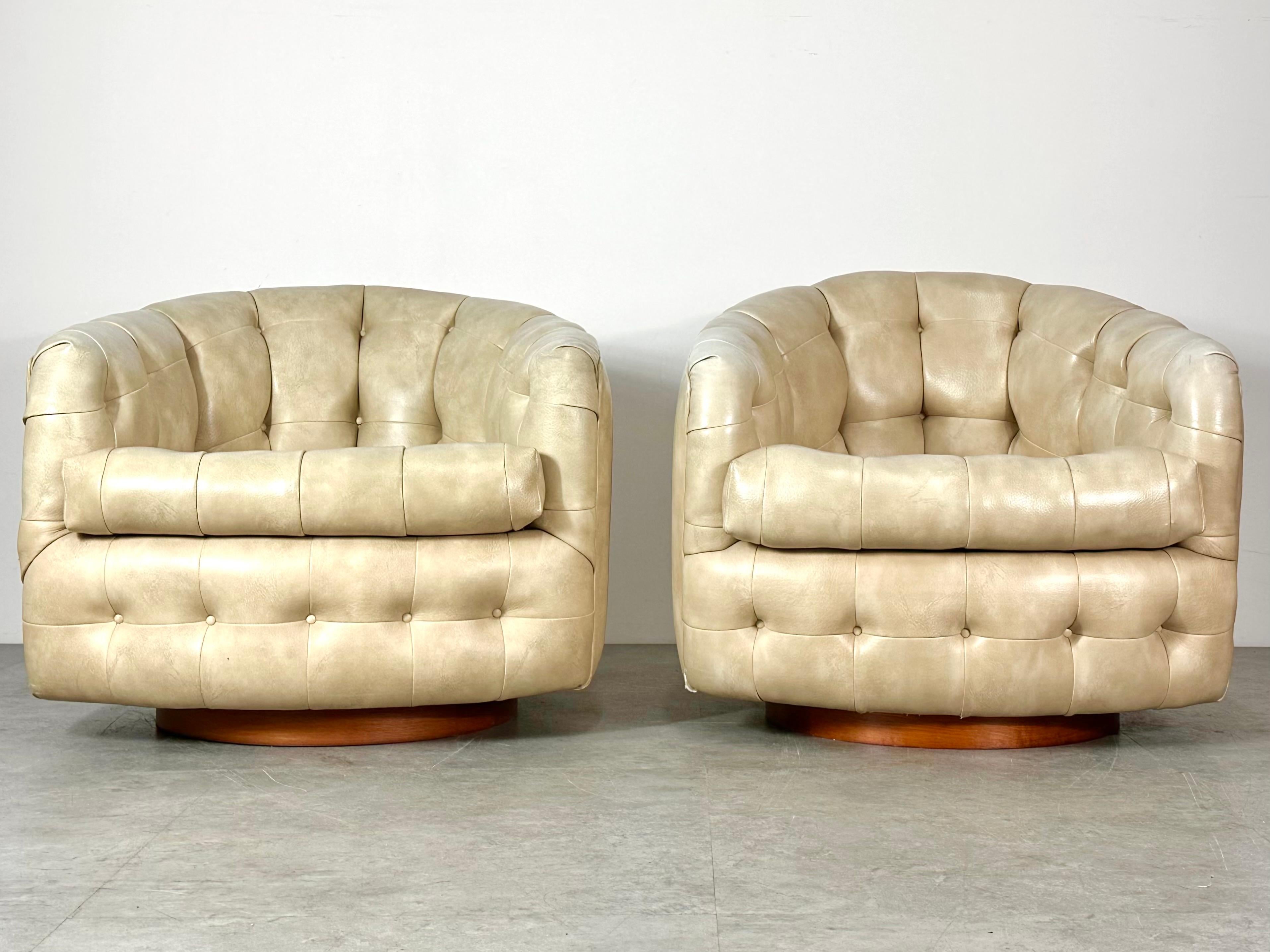 A pair of tufted swivel rocking lounge chairs designed by Milo Baughman for Thayer Coggin
Dated 1967
Barrel design in original tufted vinyl on round walnut plinth bases

Original labels intact

30