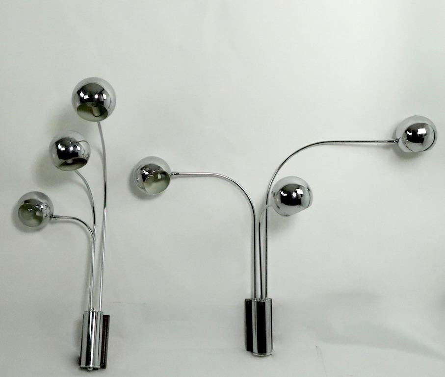 Incredible pair of mod three-arm chrome ball wall sconces by Mutual Sunset Lamp Manufacturing Company, circa 1970s. Each sconce has three arms each of which has a chrome ball shade that accepts a standard 60W screw ion bulb. The arms swing sideways