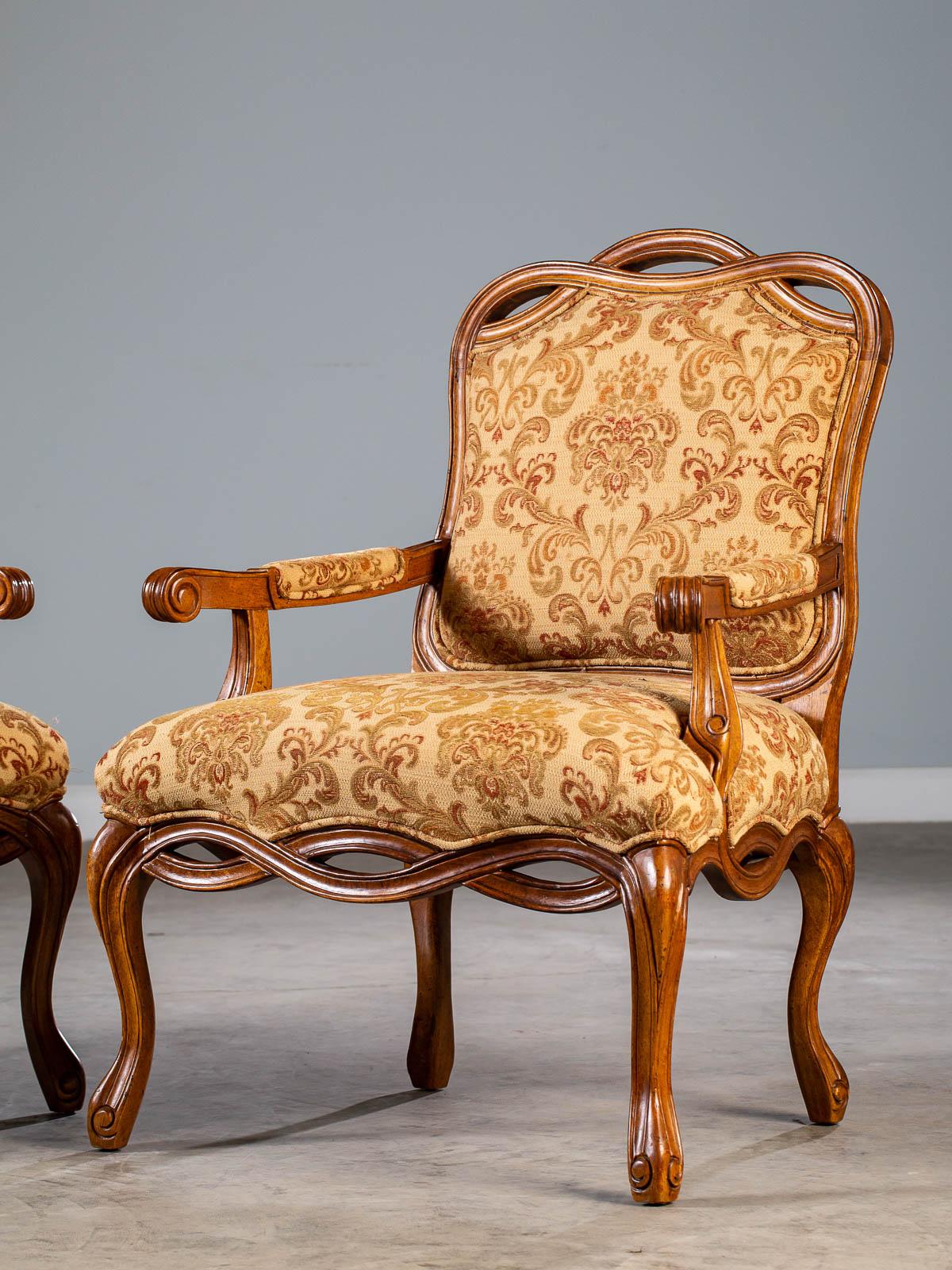 A pair of stylish modern Italian Louis XV style carved and upholstered arm chairs with a delightful woven ribbon motif having a walnut finish. Please enlarge the photographs to see that these chairs are fully carved on all four sides making them