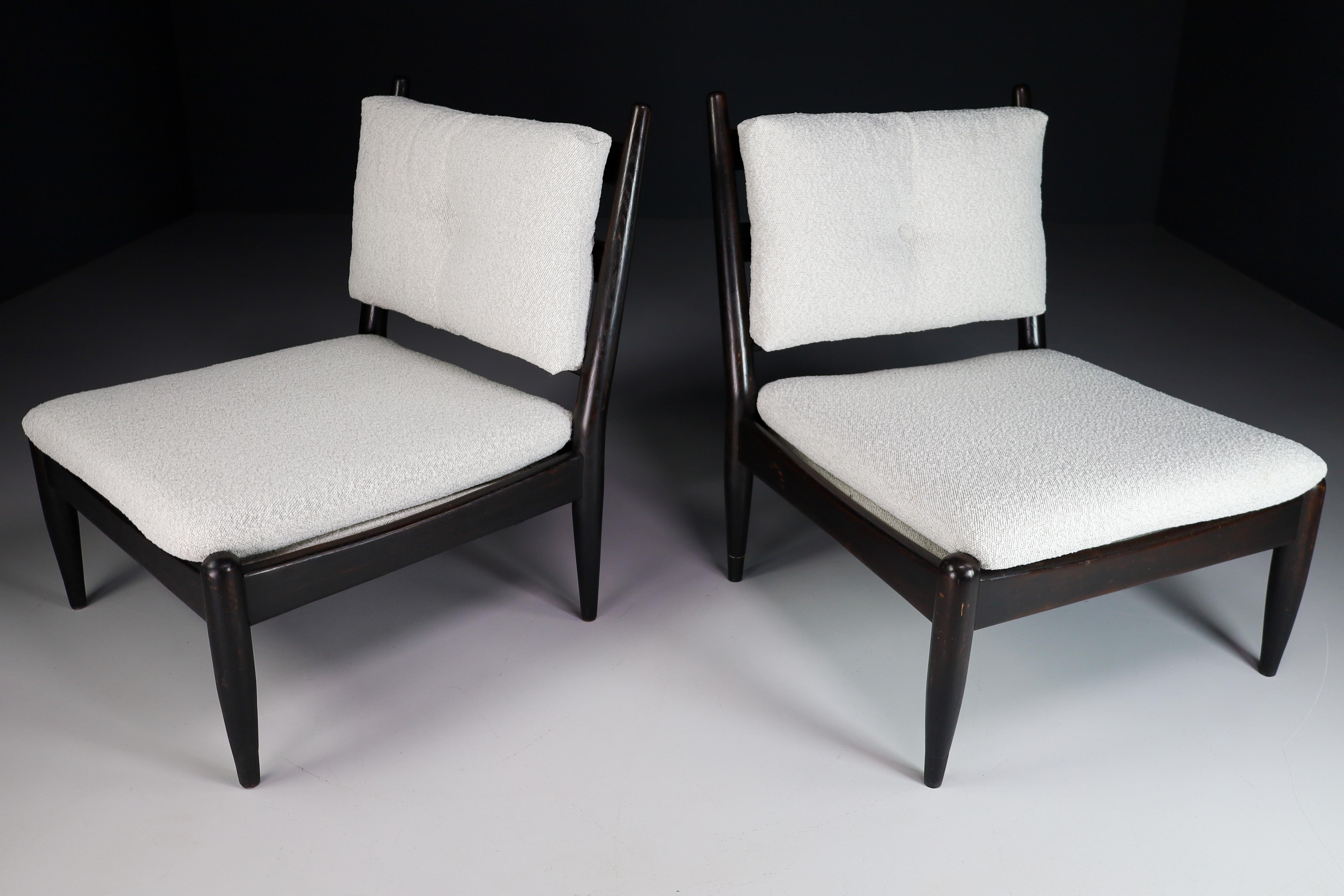 Pair of two lounge / slipper chairs with elegant frames in solid wood Re-upholstered Bouclé wool fabric, France, 1950s. Bouclé cushions provides seating comfort. Overall, an expressive set of lounge chairs and great example of modern designs. These