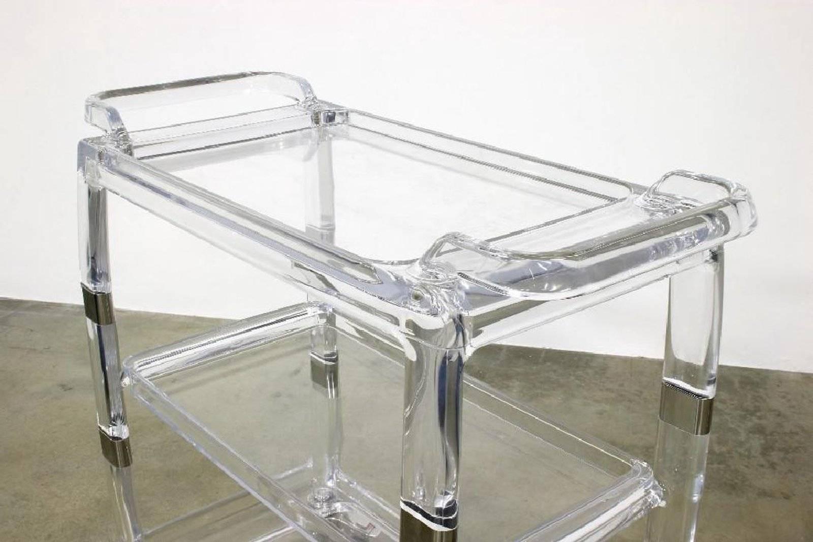 Two clear acrylic rolling bar serving carts with handles. The cart is connected by each tier through chrome hinges. The wheels are original with an Industrial look. The middle tier is removable to open a larger middle section.