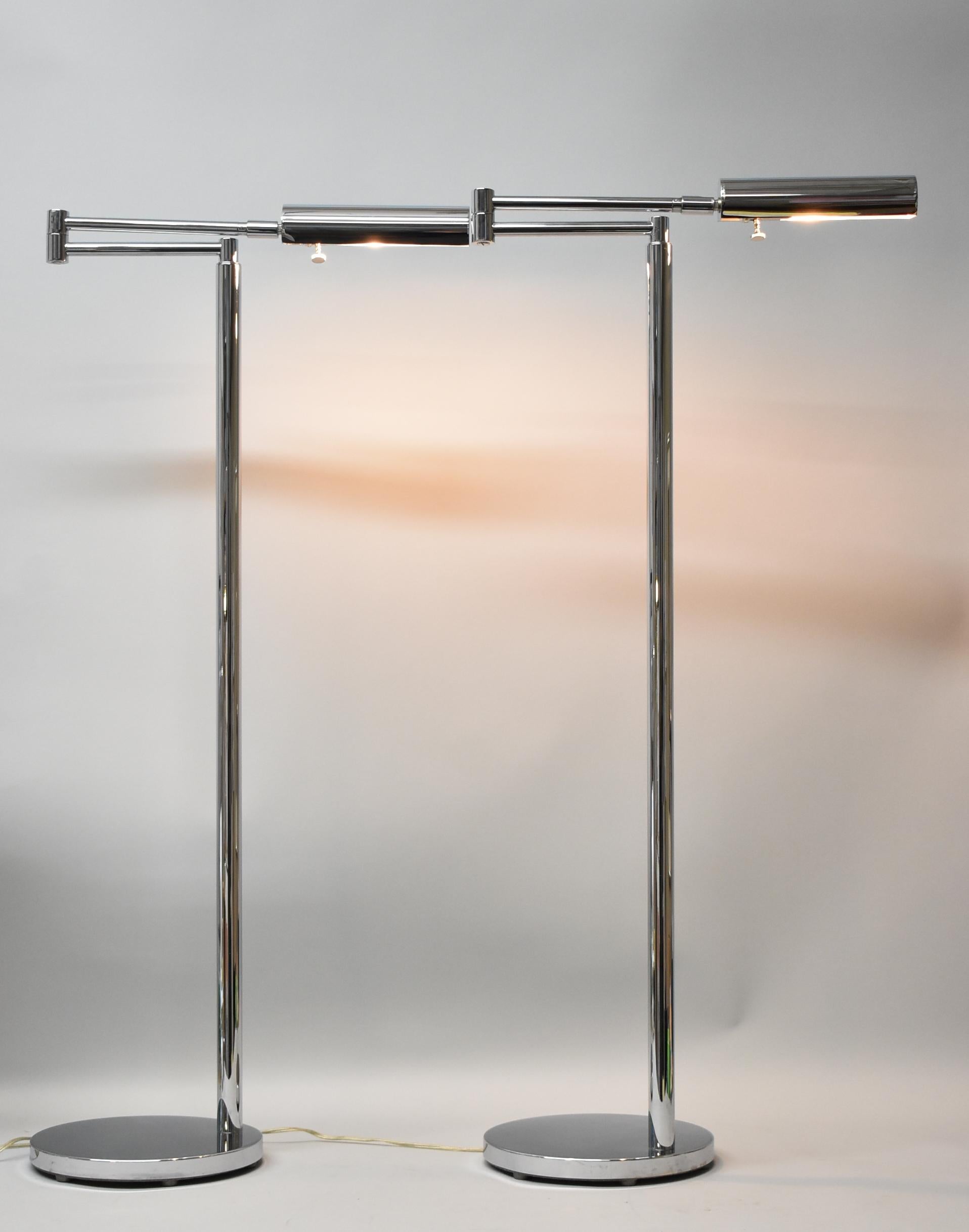 Pair of Mid Century Modern retractable chrome cylinder floor lamps by Nessen Koch & Lowy. Single socket. Shade swivels and rotates. One small dent in the base and light scratches. Dimensions: 10