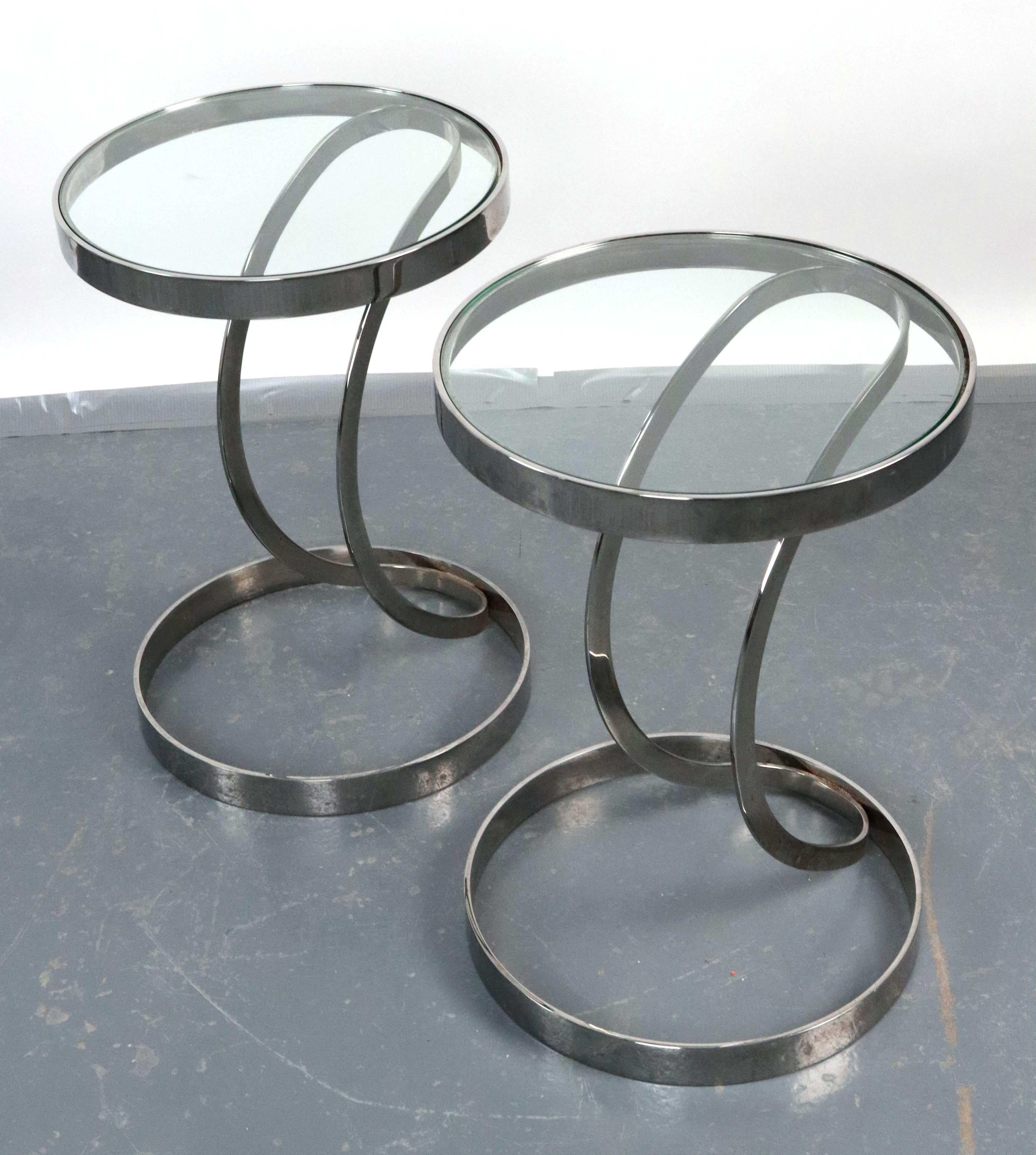 Diese Tische haben eine runde Klarglasplatte und ein verchromtes Stahlgestell. Der Sockel besteht aus einem runden Ring am Boden und einem gebogenen Metallteil, das sich erhebt, um die Glasplatte zu tragen. Guter Zustand mit oberflächlichen