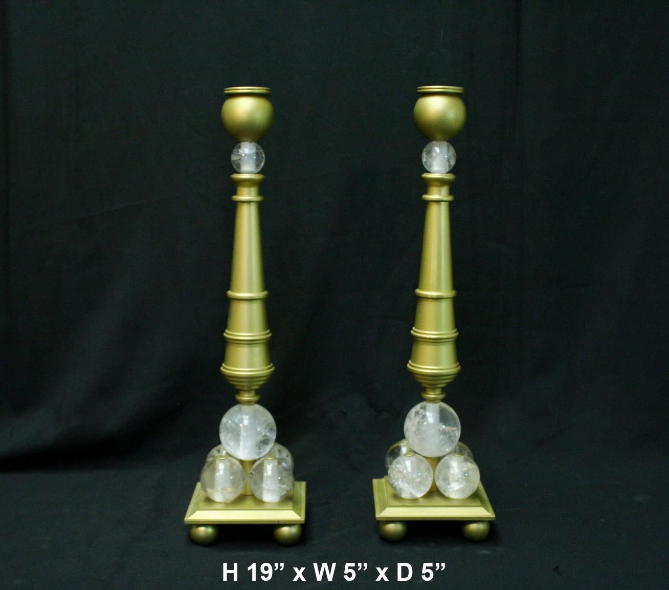 Lovely pair of modern style rock crystal gold bronze candlesticks.
A bulbous candleholder is over a tapered turned shaft, supported by five hand carved and hand polished Rock Crystal balls, all raised on stepped base with four bronze ball feet.