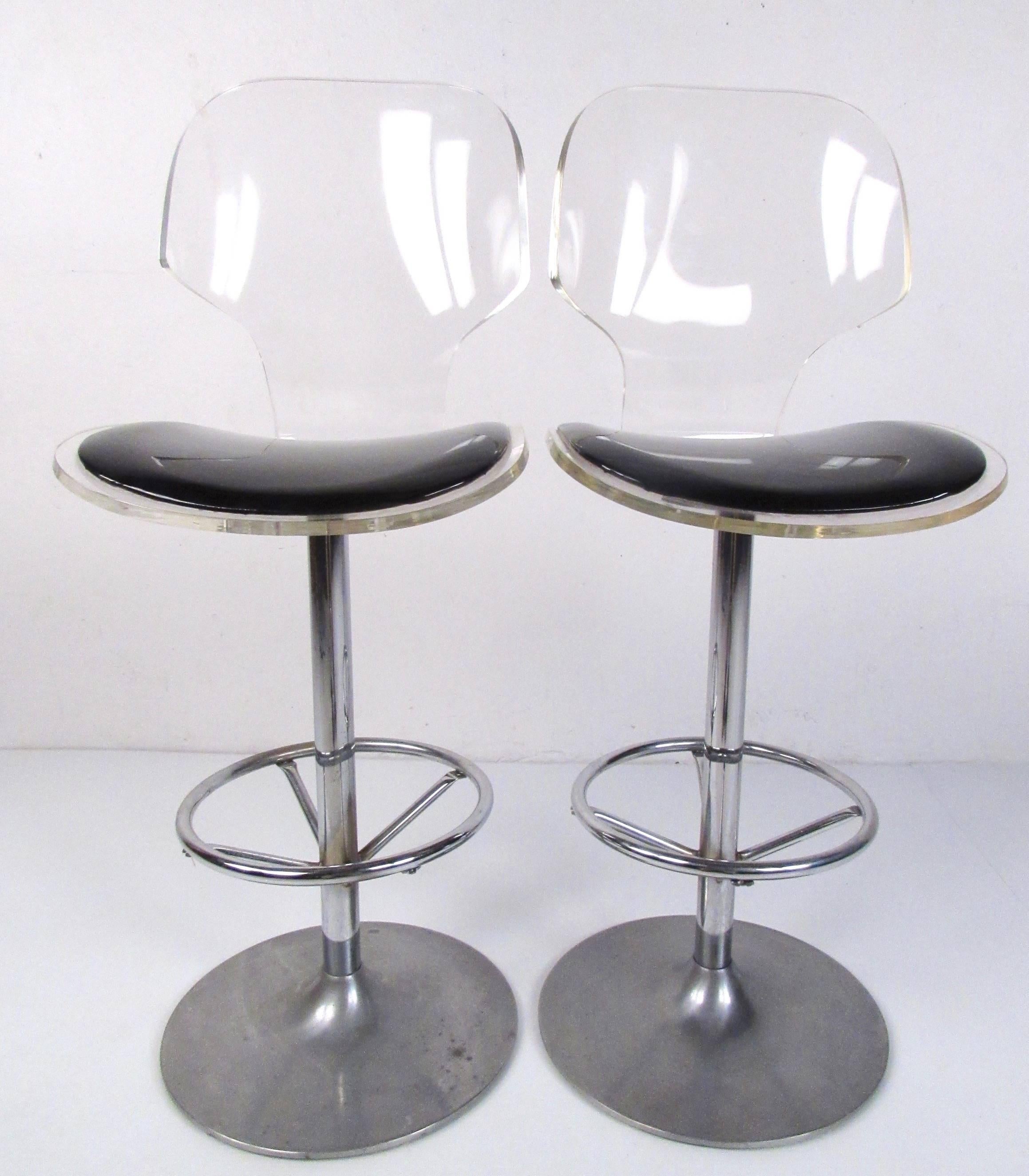 This stylish pair of vintage modern acrylic barstools by Hill manufacturing feature swivel aluminum bases with circular footrests and make a unique and comfortable midcentury-style addition to any interior. Measure: 29-inch seat height makes these