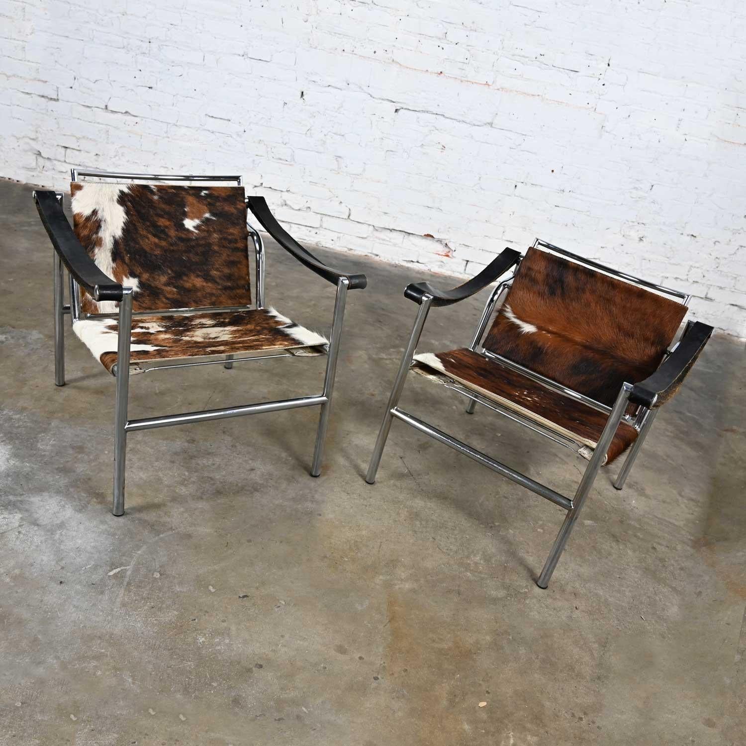 Gorgeous pair of vintage Modernist, Bauhaus, or Art Deco Basculant LC1 Sling Chairs attributed to Le Corbusier. Comprised of chrome plated tubular steel frames, spring seat platforms and back cross straps, black leather arm rest straps, and hair-on