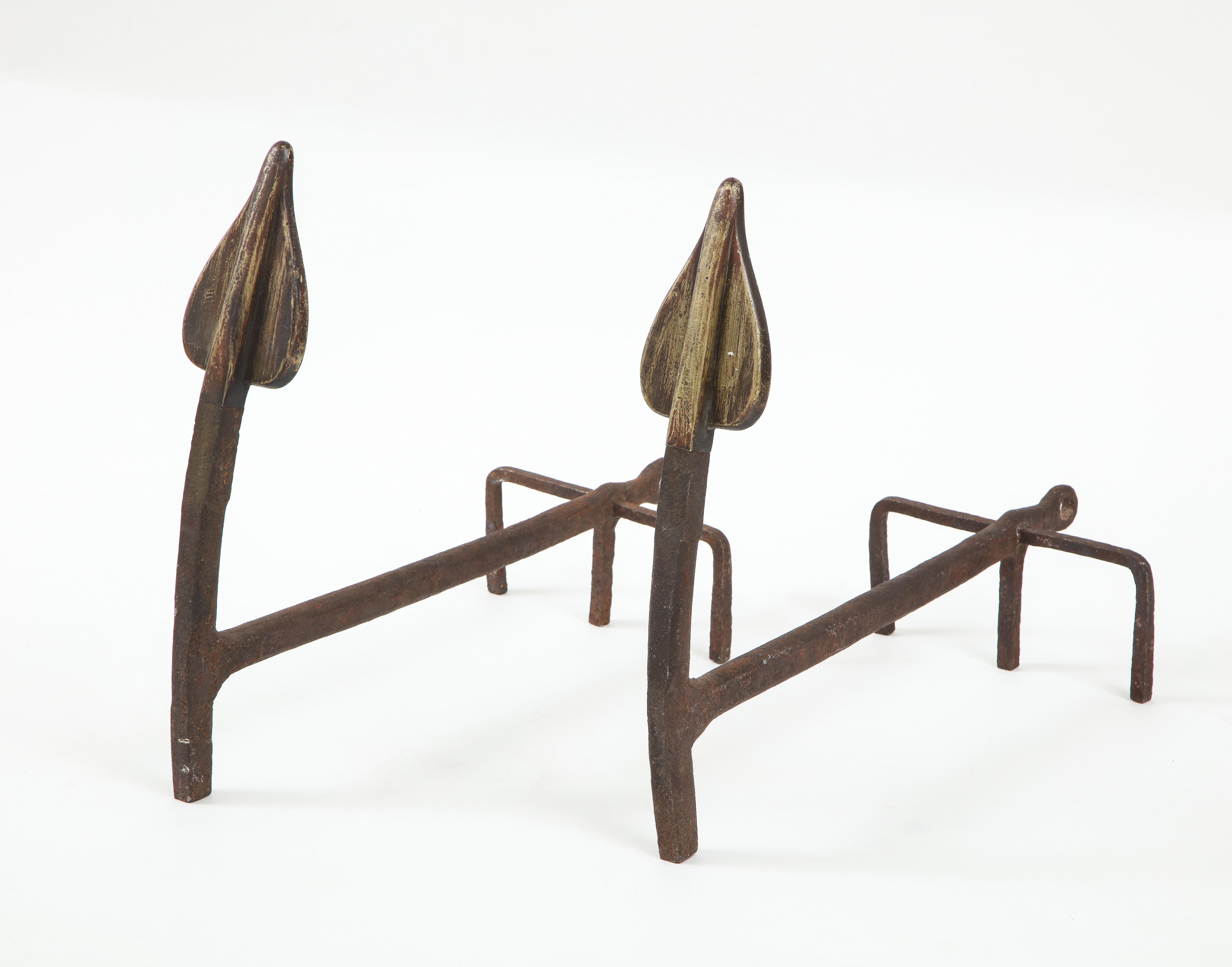 A pair modernist handwrought fireplace Andirons. These gently bent arrows that are artisan crafted fireplace pieces are forged in wrought iron.
