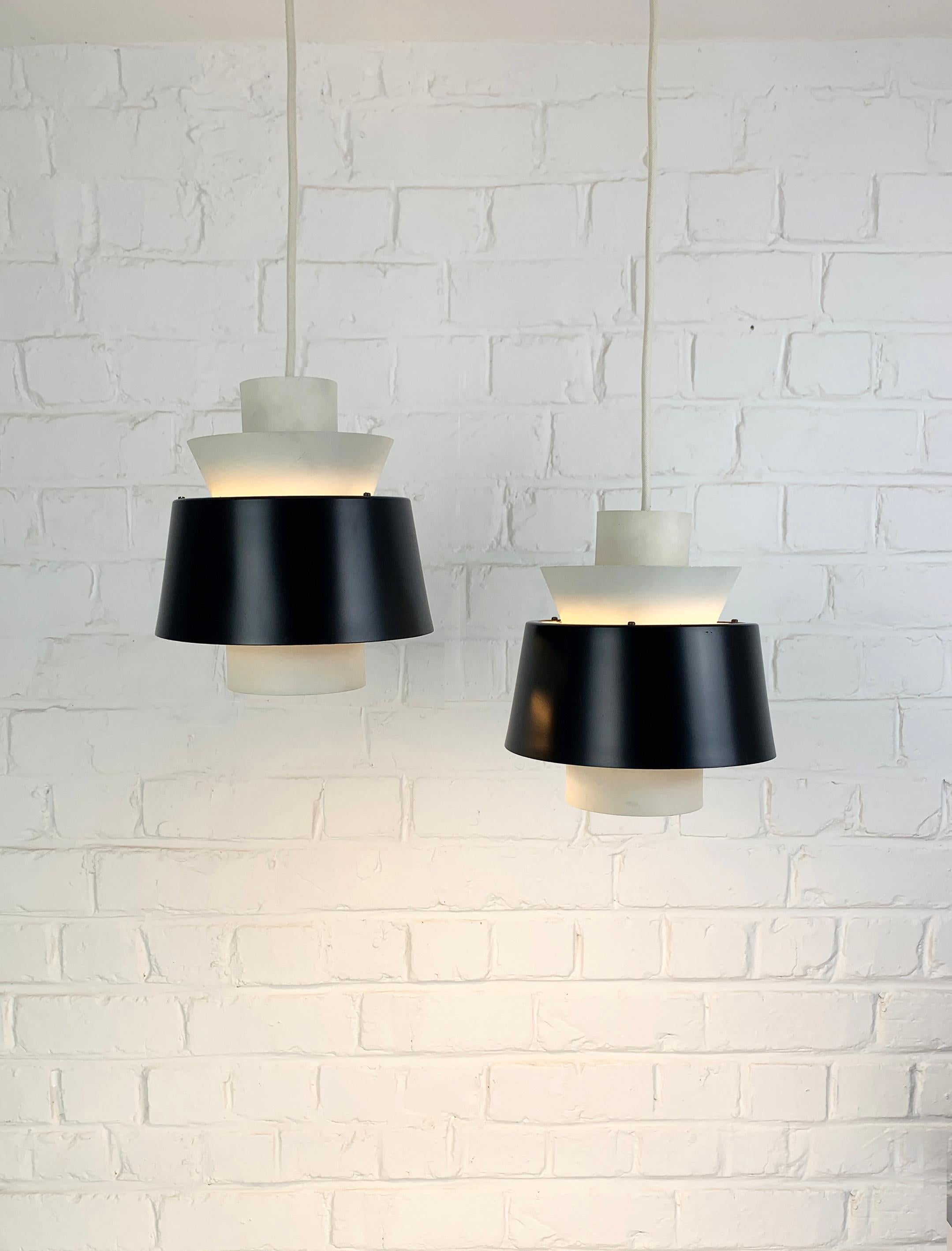 Pair vintage Tivoli Pendant lamps in black & white. Manufactured by Nordisk Solar during the 1950s or 1960s.

The Tivoli pendant was designed in 1947 by Danish architect Jørn Utzon, long before his renowned win of the architectural competition for