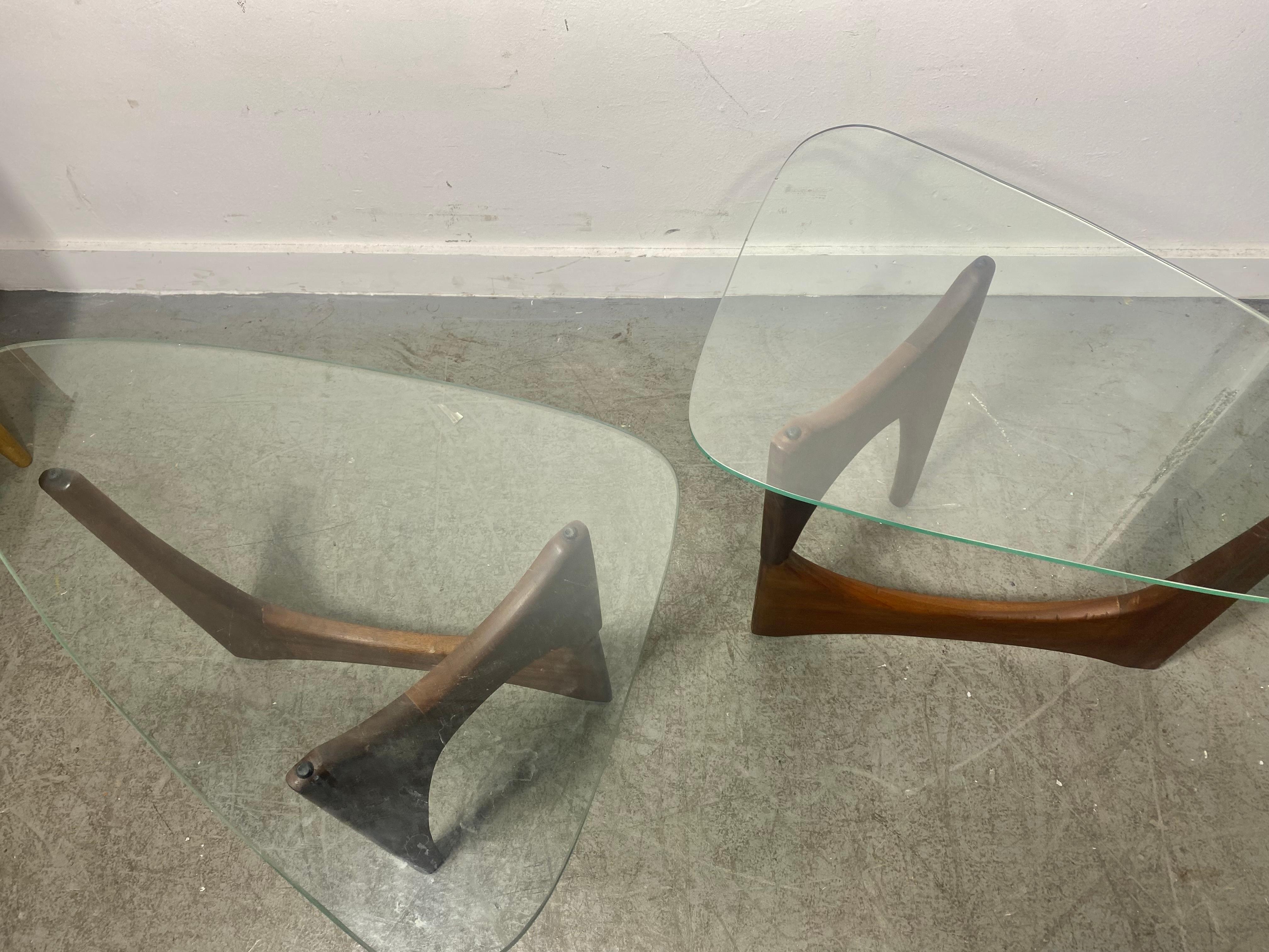 
Pair Modernist Sculptural Walnut and Glass end tables attributed to Adrian Pearsall,, Similar to classic design by Isamu Noguchi. Two piece sculpted walnut base's. Retains original guitar pick shape glass tops. on tiny flake (chip).