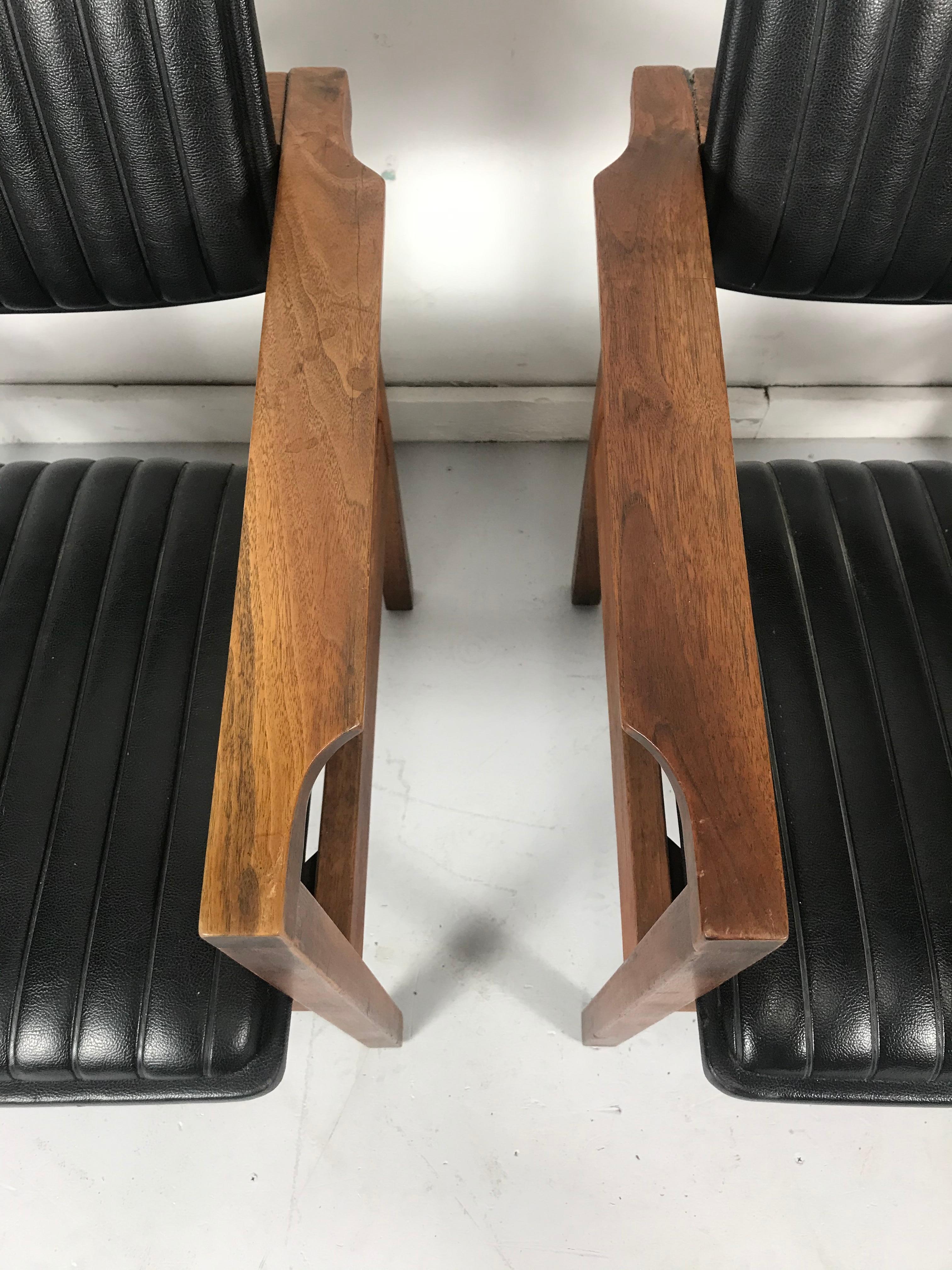 Pair of modernist walnut and channeled Naugahyde lounge chairs attributed to Jens Risom. Wonderful design. Channeled seats and backs similar to 1950s car interior seats. Extremely comfortable, Classic modernist design.