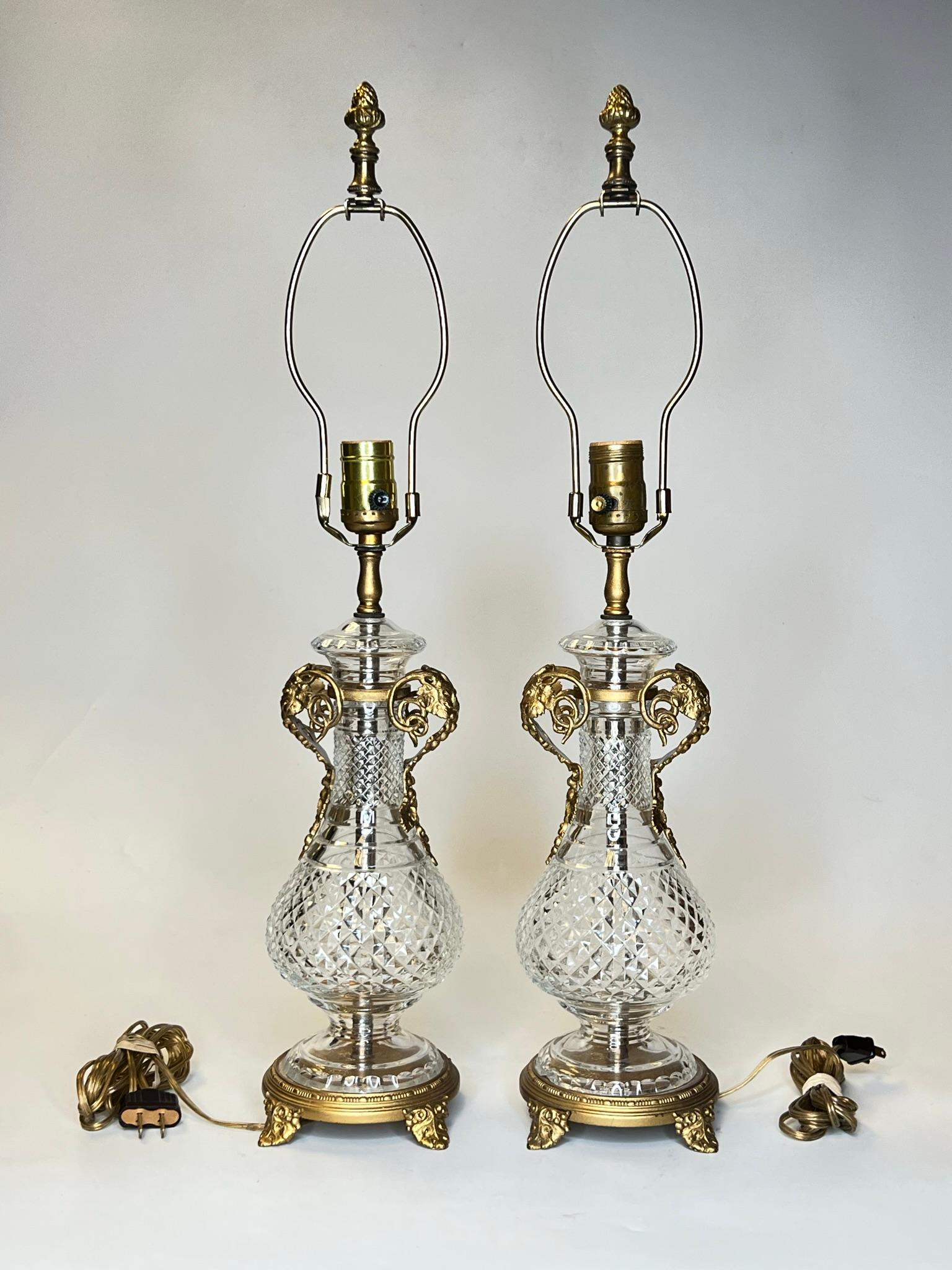 Pair of antique table lamps from the Mutual Sunset Lamp Company, of urn form, crafted from molded glass with foliate gilt bronze handles and pedestals.  Ready for use.