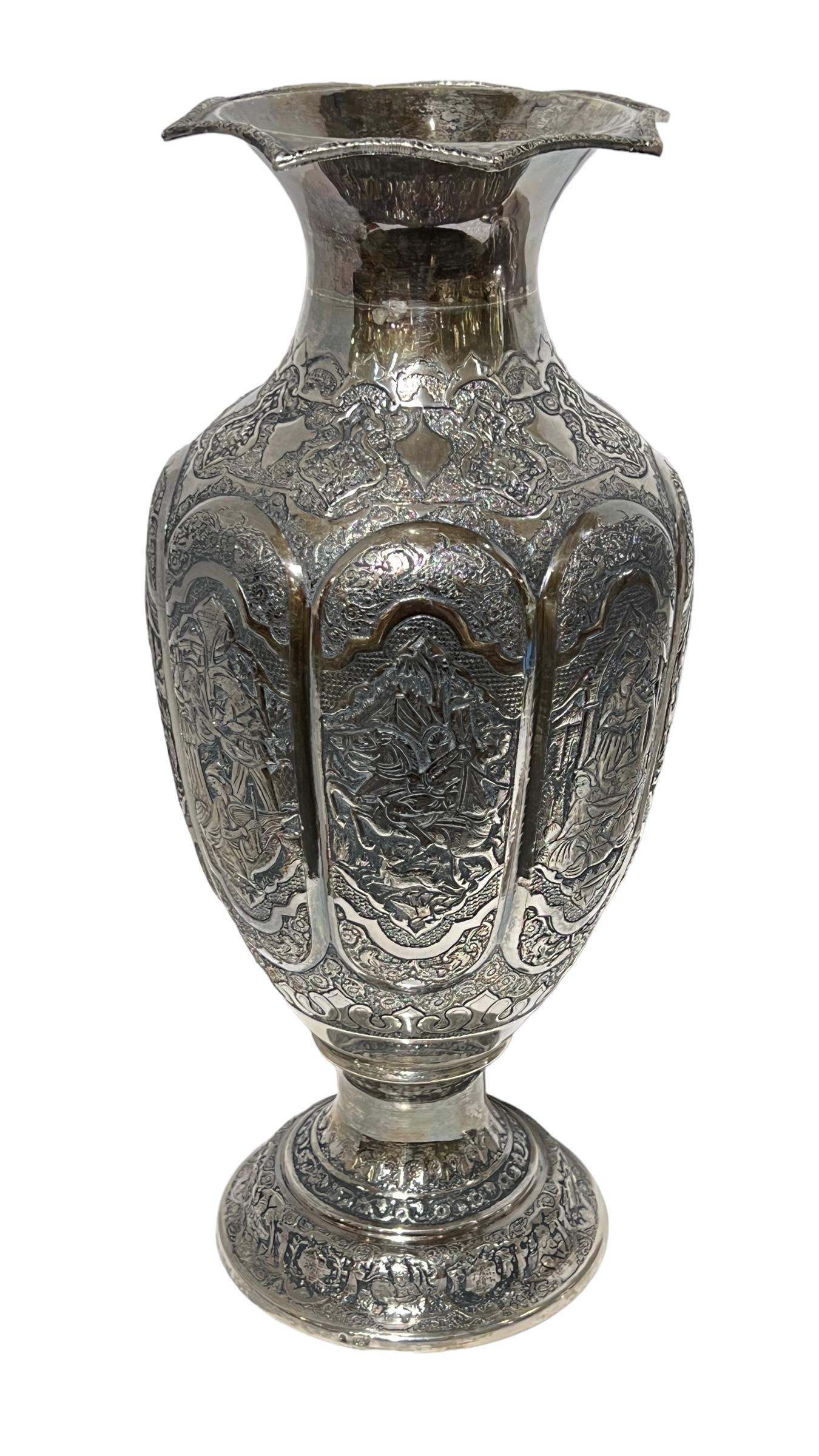  pair of Persian silver vases with extensive chased and repousse designs including bulbous cartouches depicting men hunting on horseback and women preparing a bountiful meal.  Each 19 inches tall and 7 3/4 inches across.  Weights:  2,350 g, 82.89